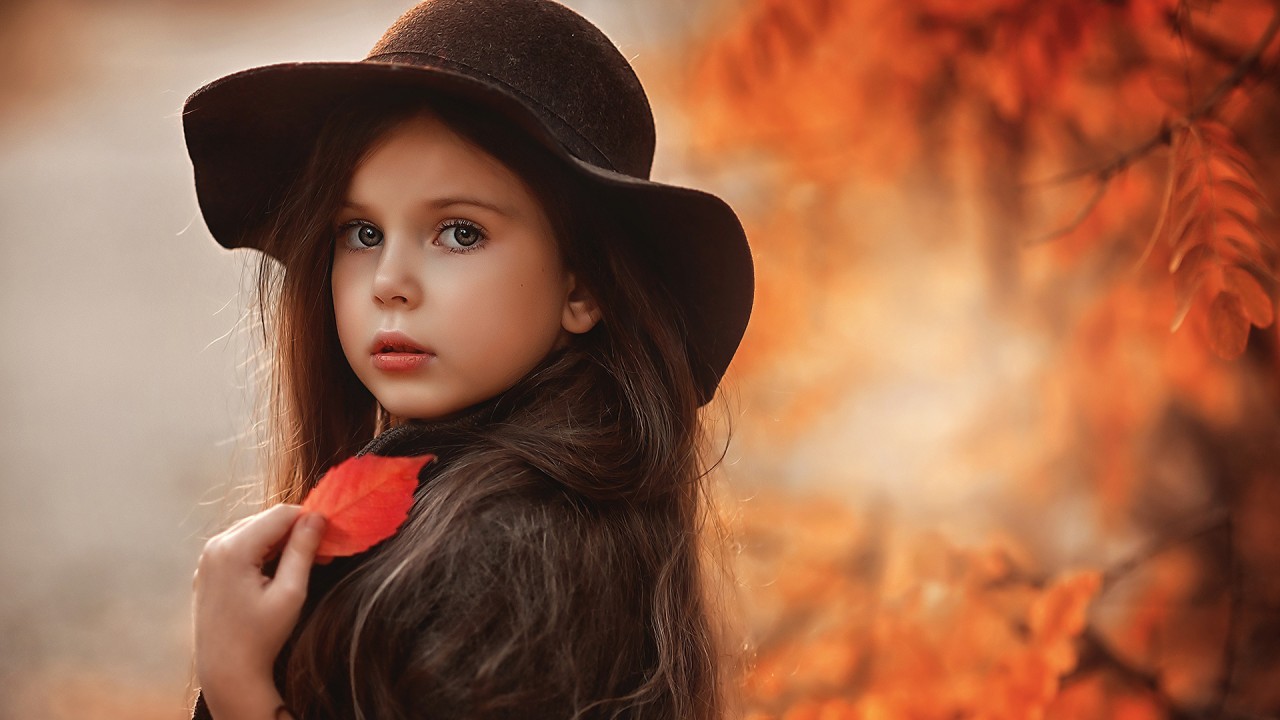 Cute Little Girl Is Wearing Black Overcoat And Hat Standing In Blur Autumn Leaves Background HD Cute Wallpaper