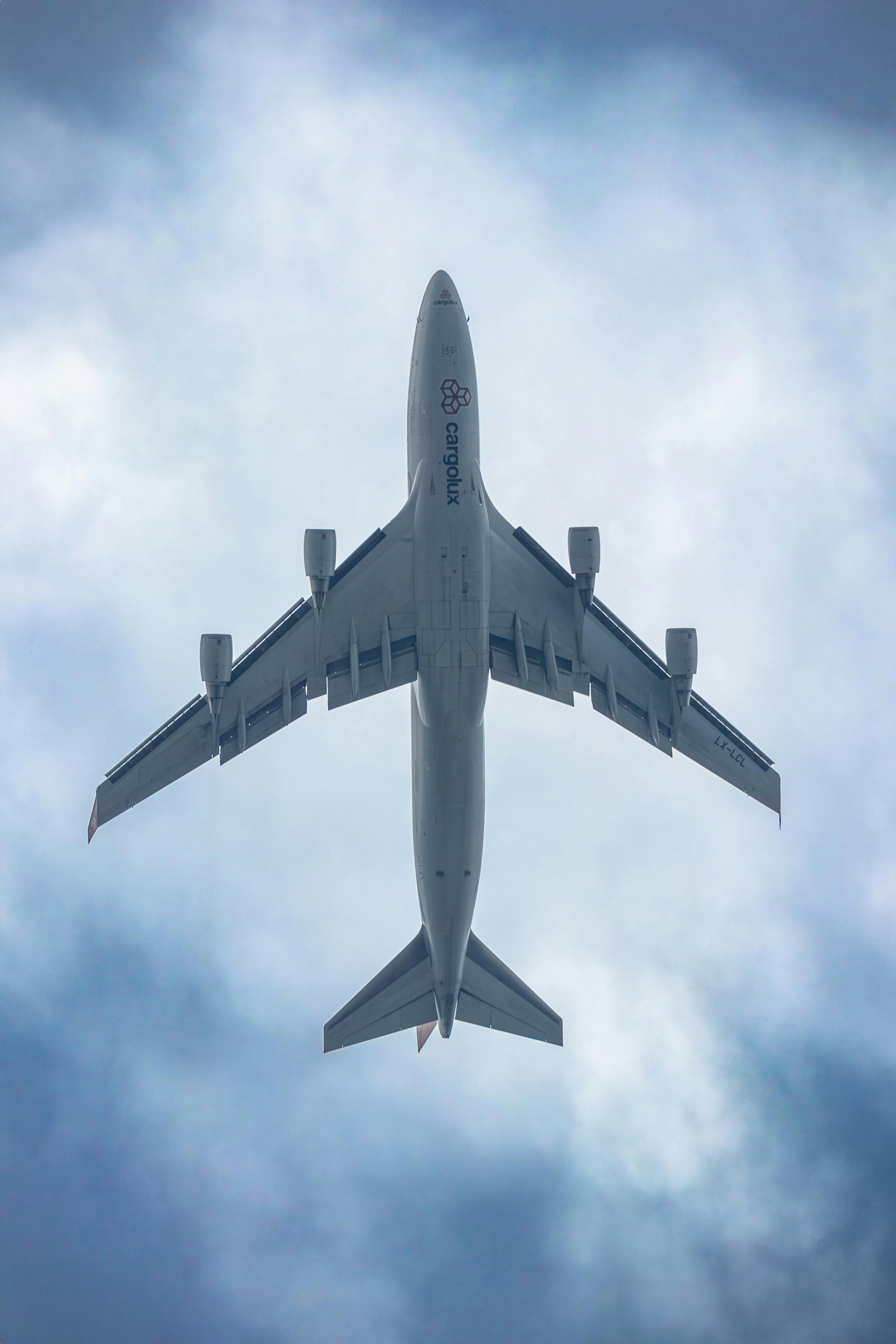 White And Red Plane Beside Clouds Low Angle Photography · Free