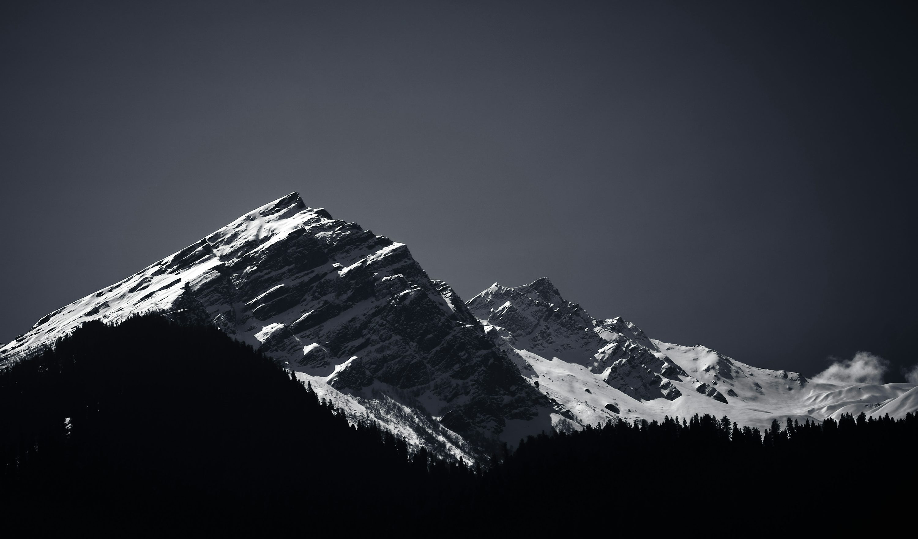 A black and white photo of a snow covered mountain photo