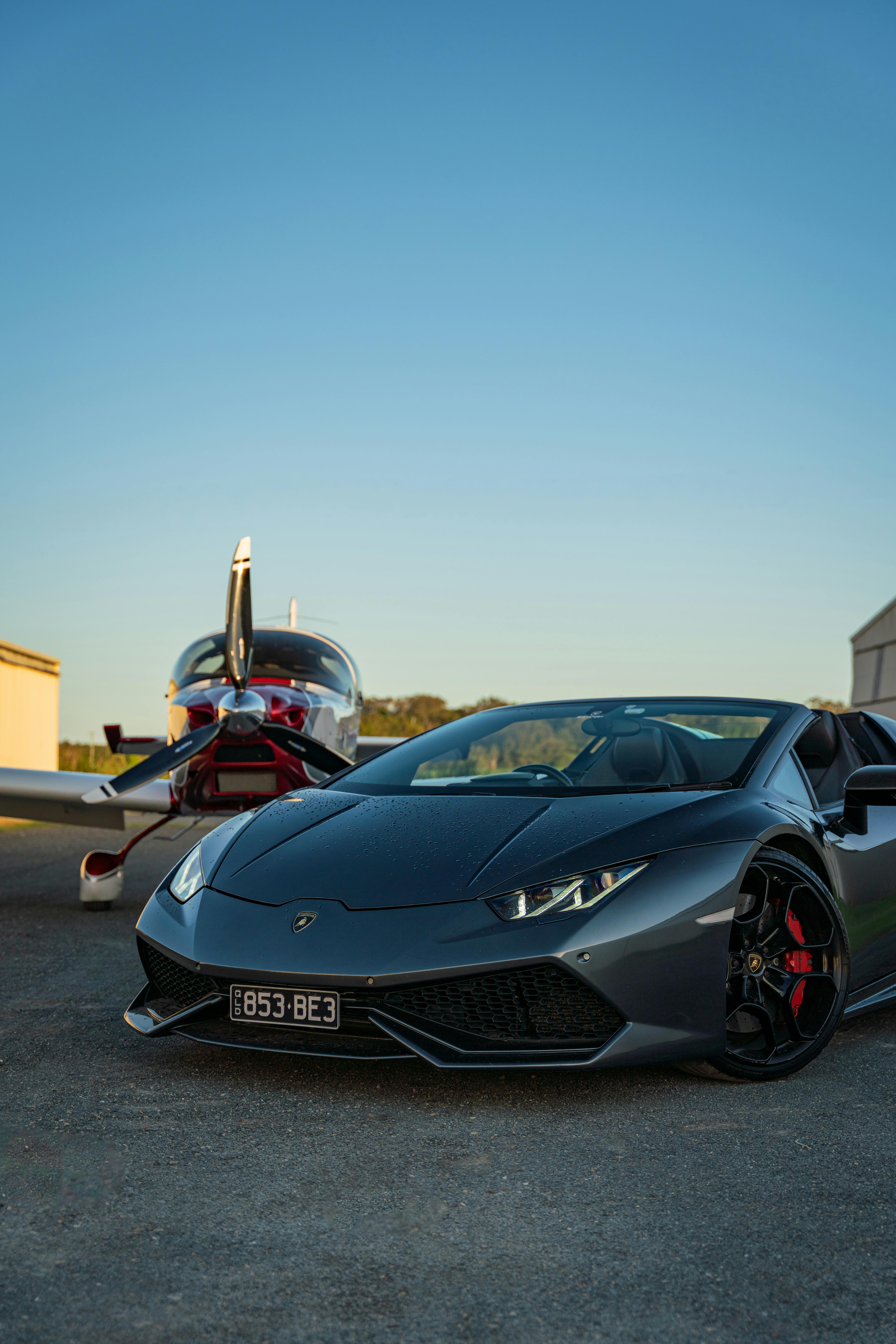 A Lamborghini Huracan Parked next to a Plane · Free