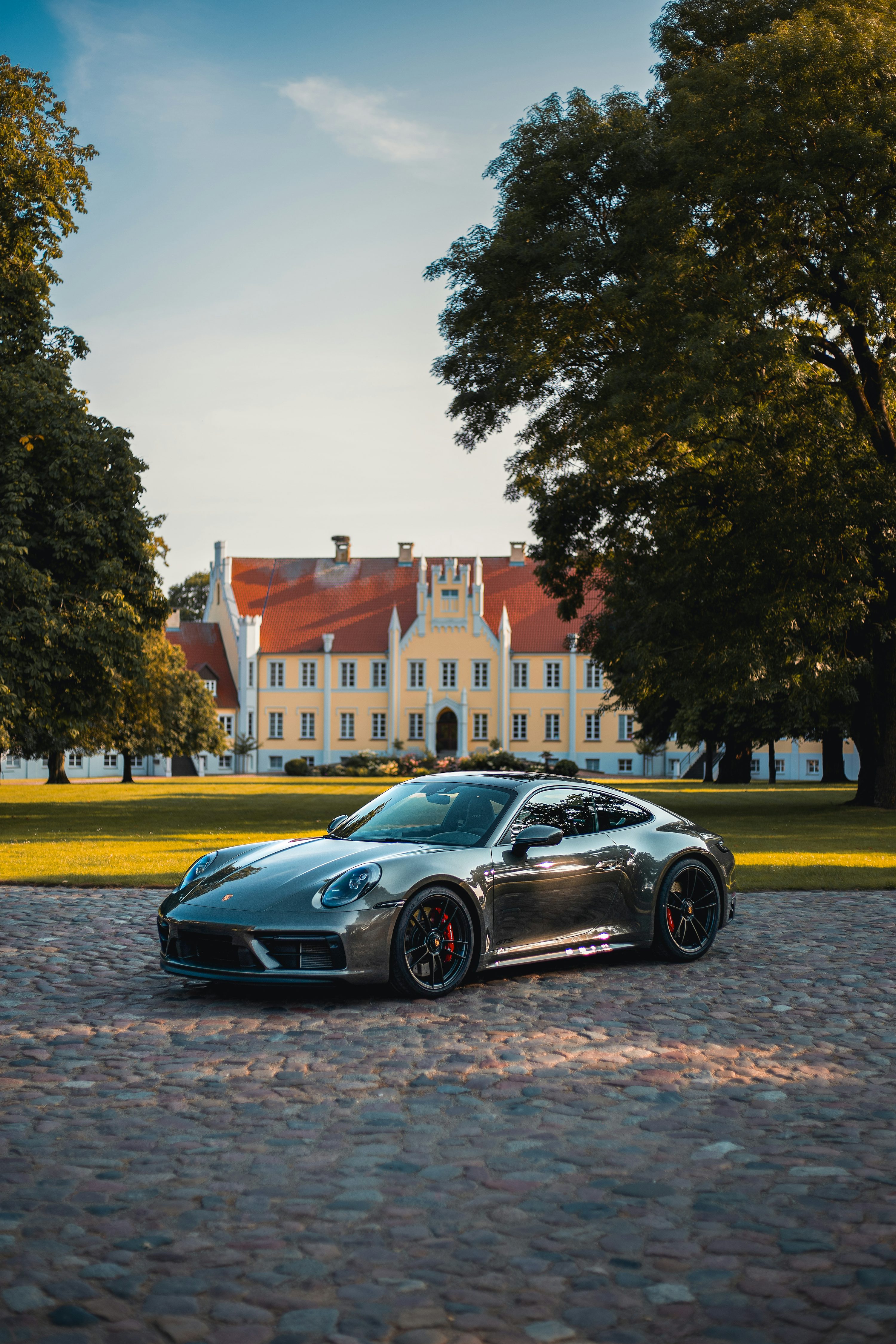 Sleek porsche parked in front of a mansion. photo