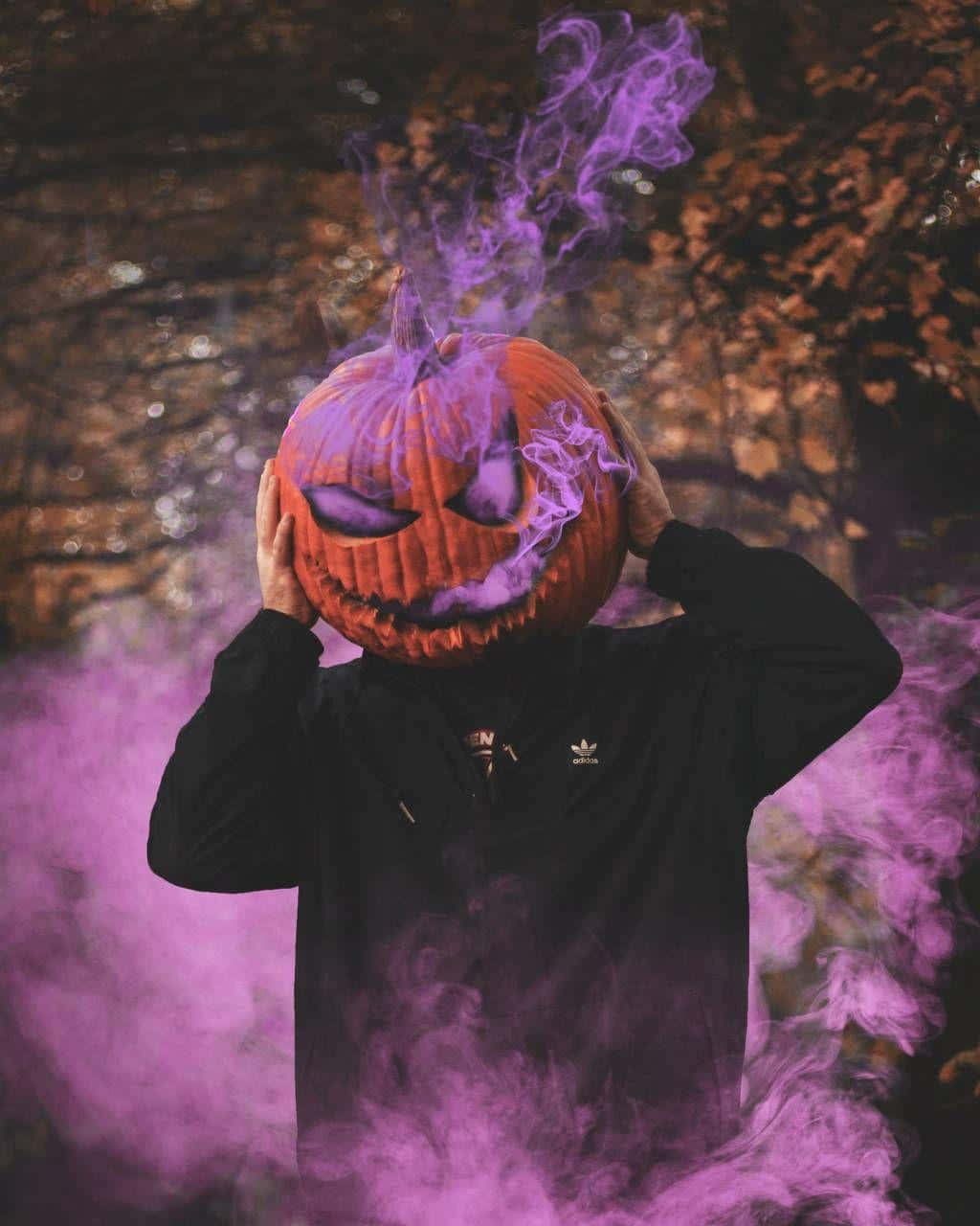 Download A Man With A Purple Pumpkin Mask And Smoke Wallpaper