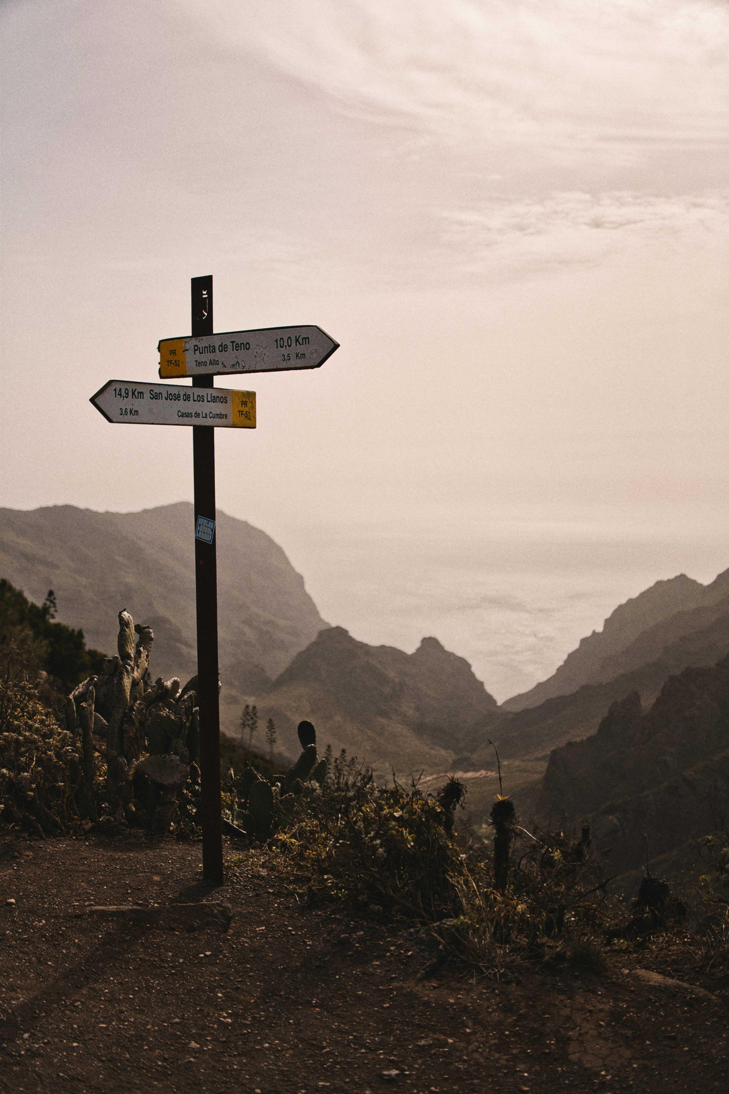 Signpost in a mountain valley with distant ocean view photo