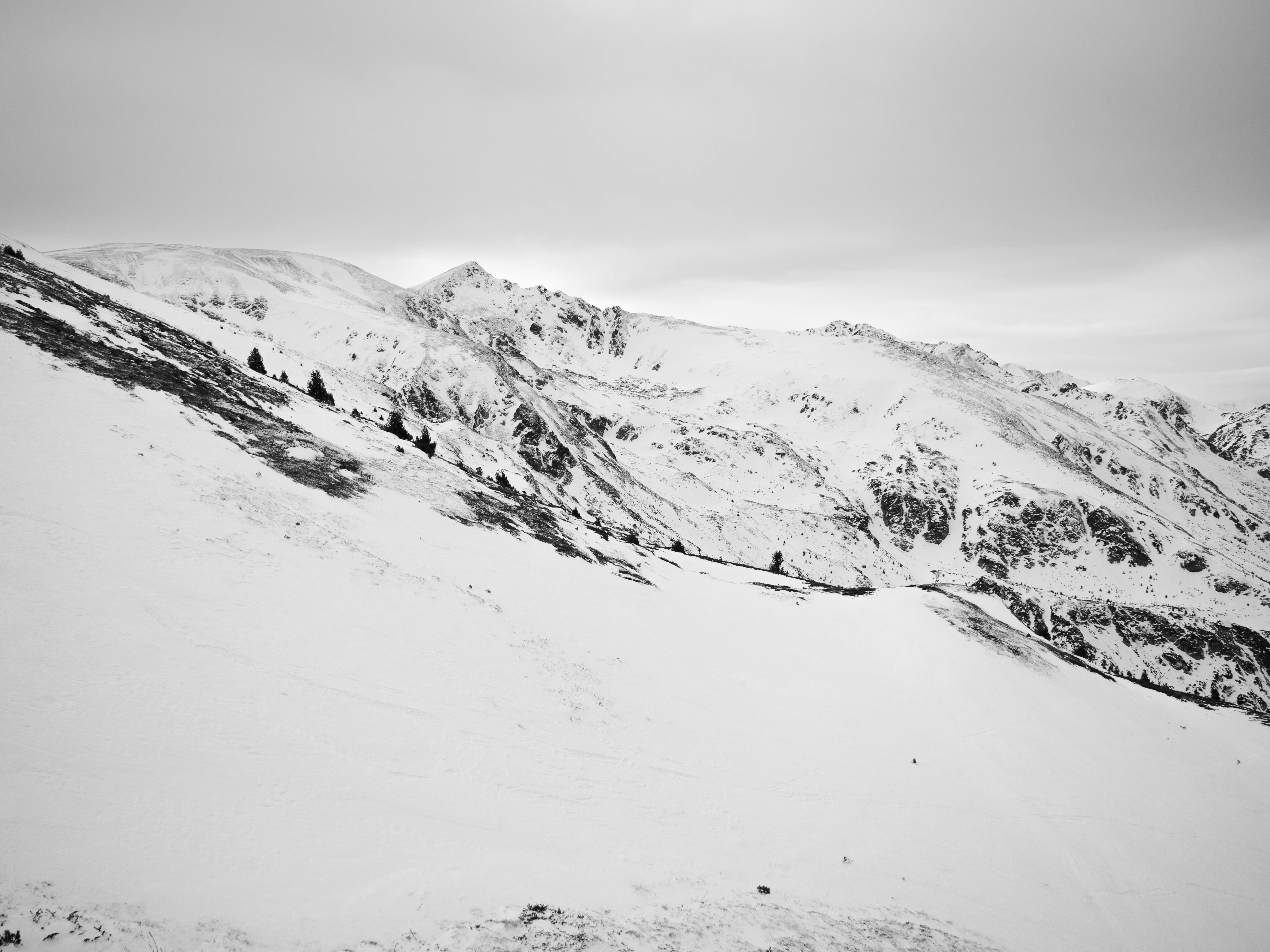 A black and white photo of a snowy mountain · Free