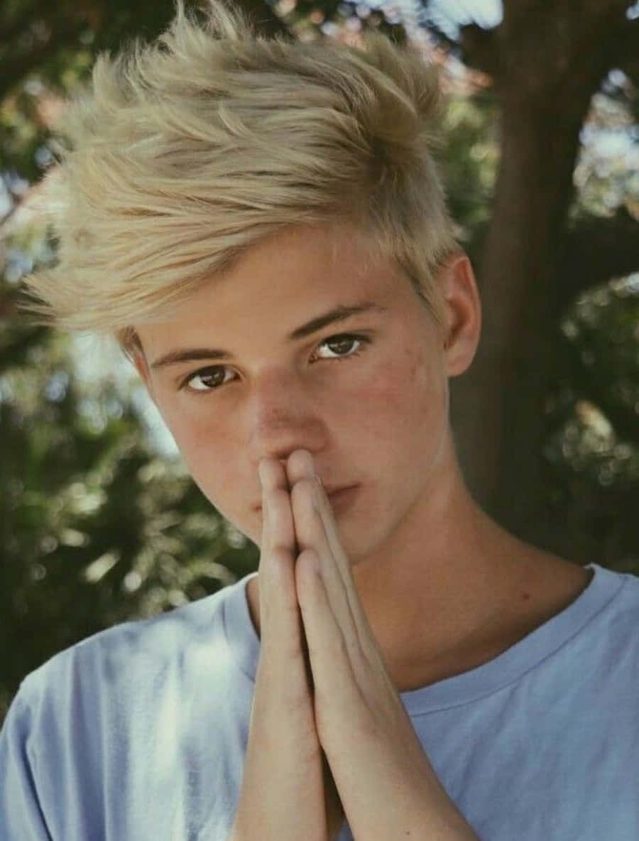Download A Young Man With Blonde Hair Is Praying