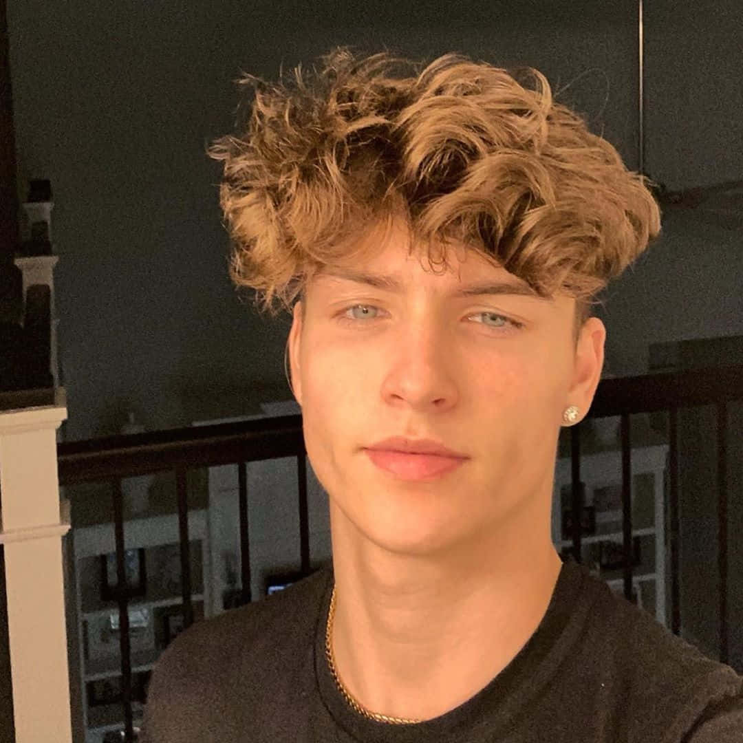 Download Stylish Young Manwith Curly Hair Wallpaper