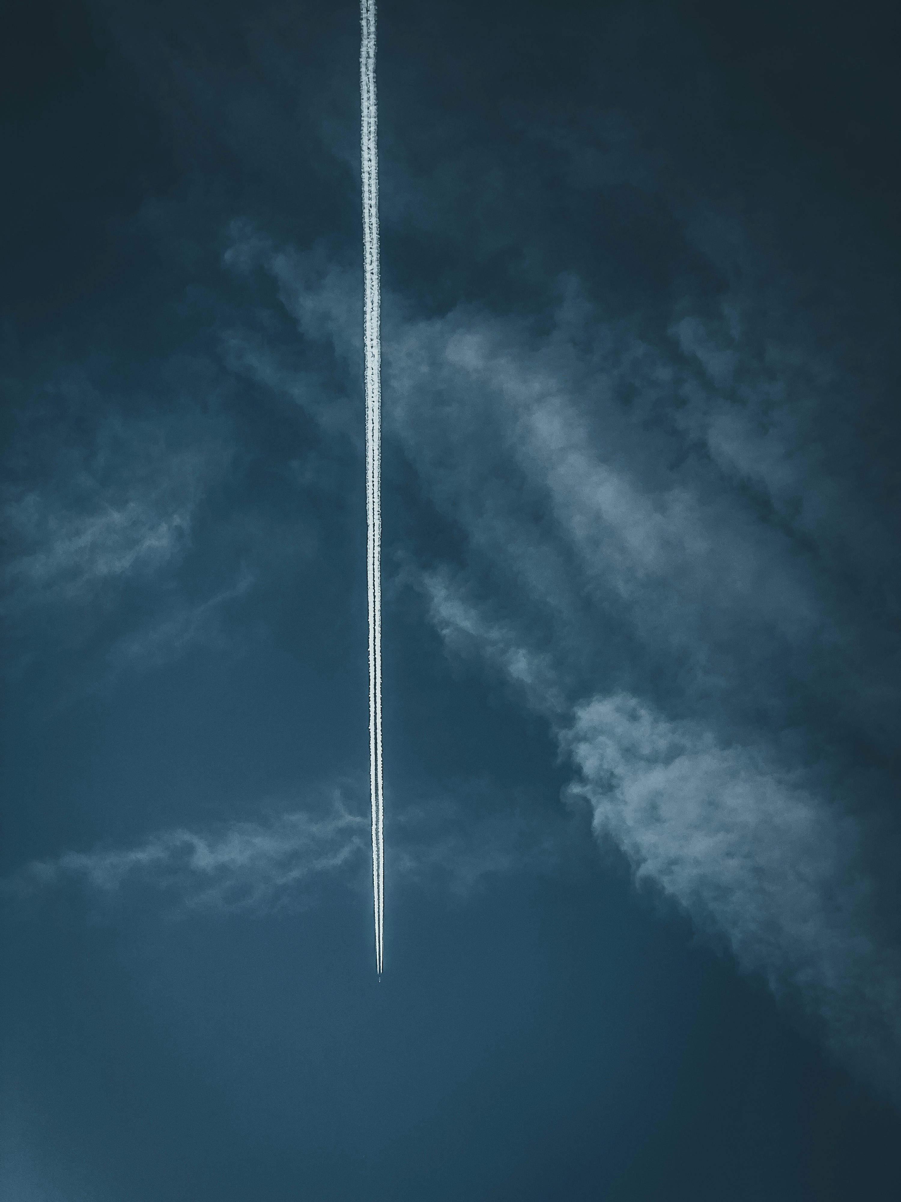 An airplane is flying in the sky with a contrail photo