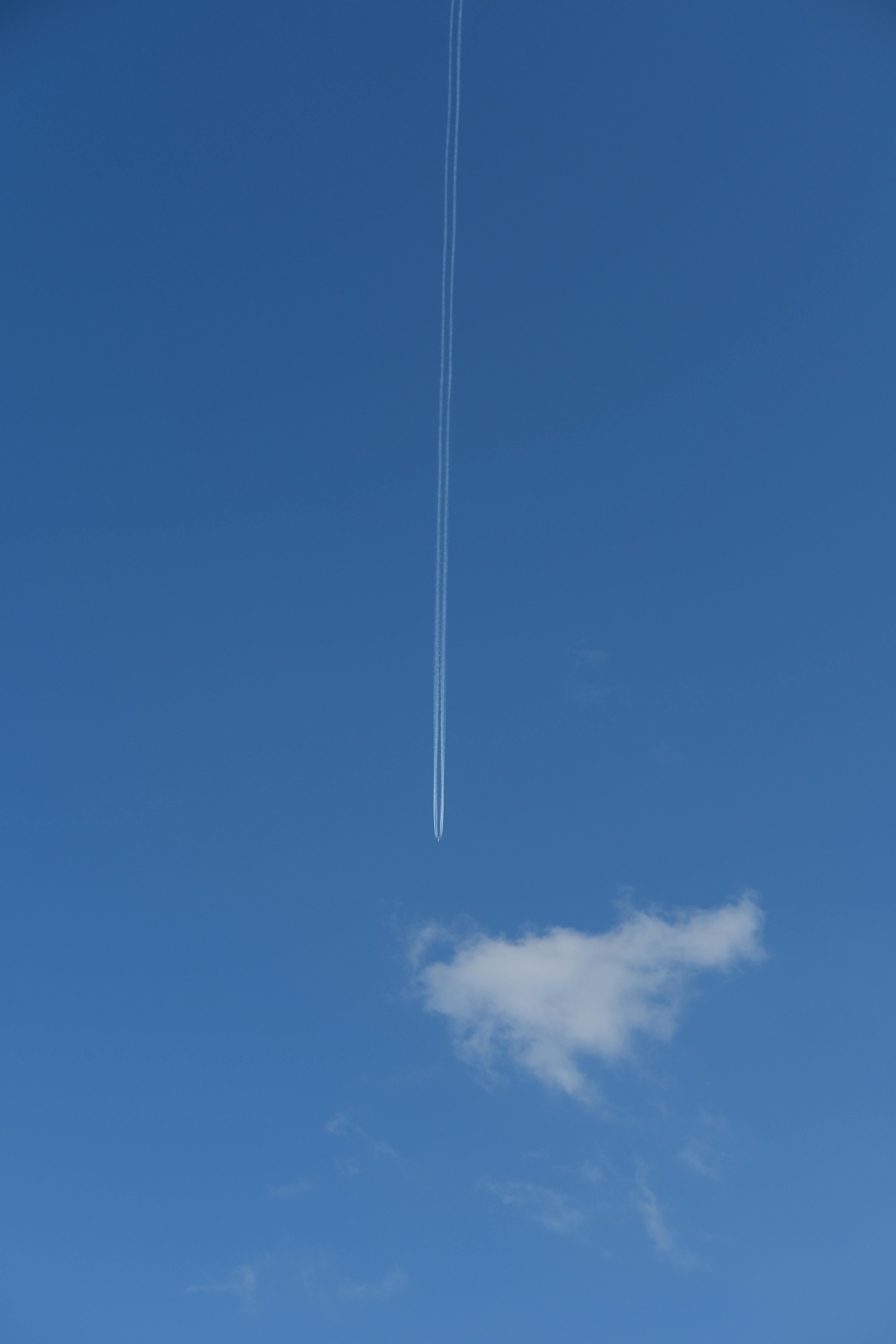 Contrails behind an Airplane against Blue Sky · Free