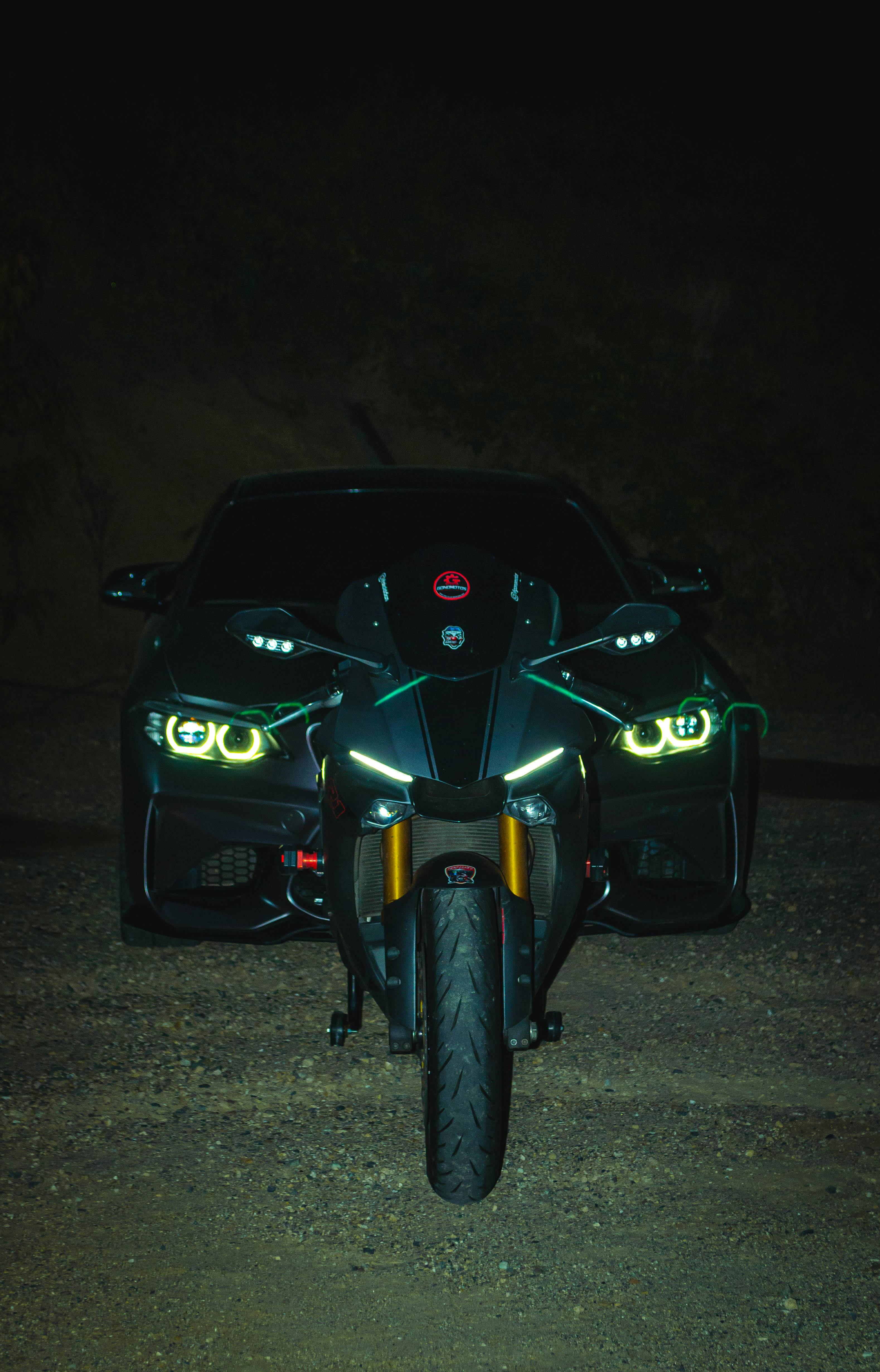 Motorcycle in Front of a Luxurious BMW Car at Night · Free