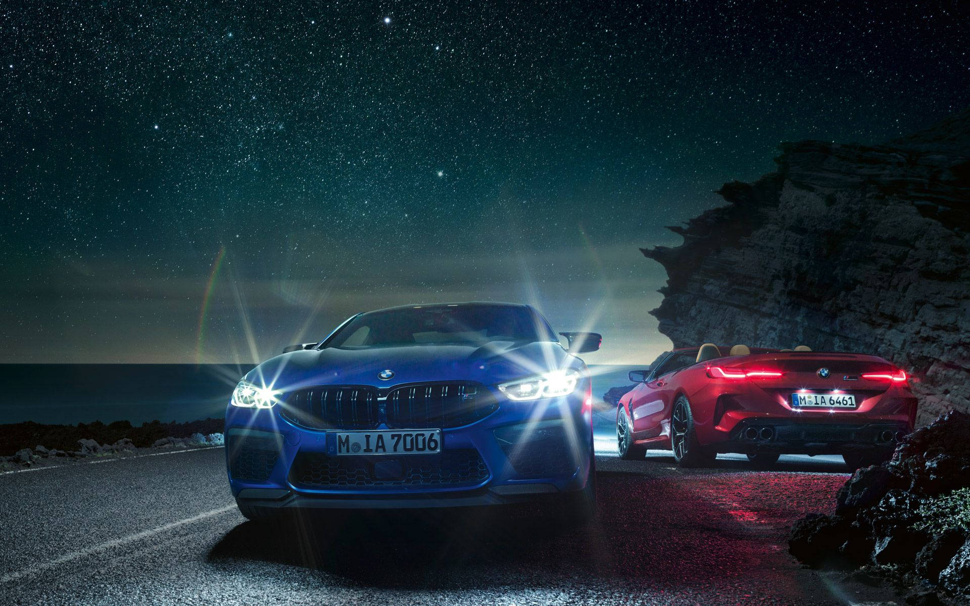 Download Luxurious Blue BMW Driving At Night Wallpaper