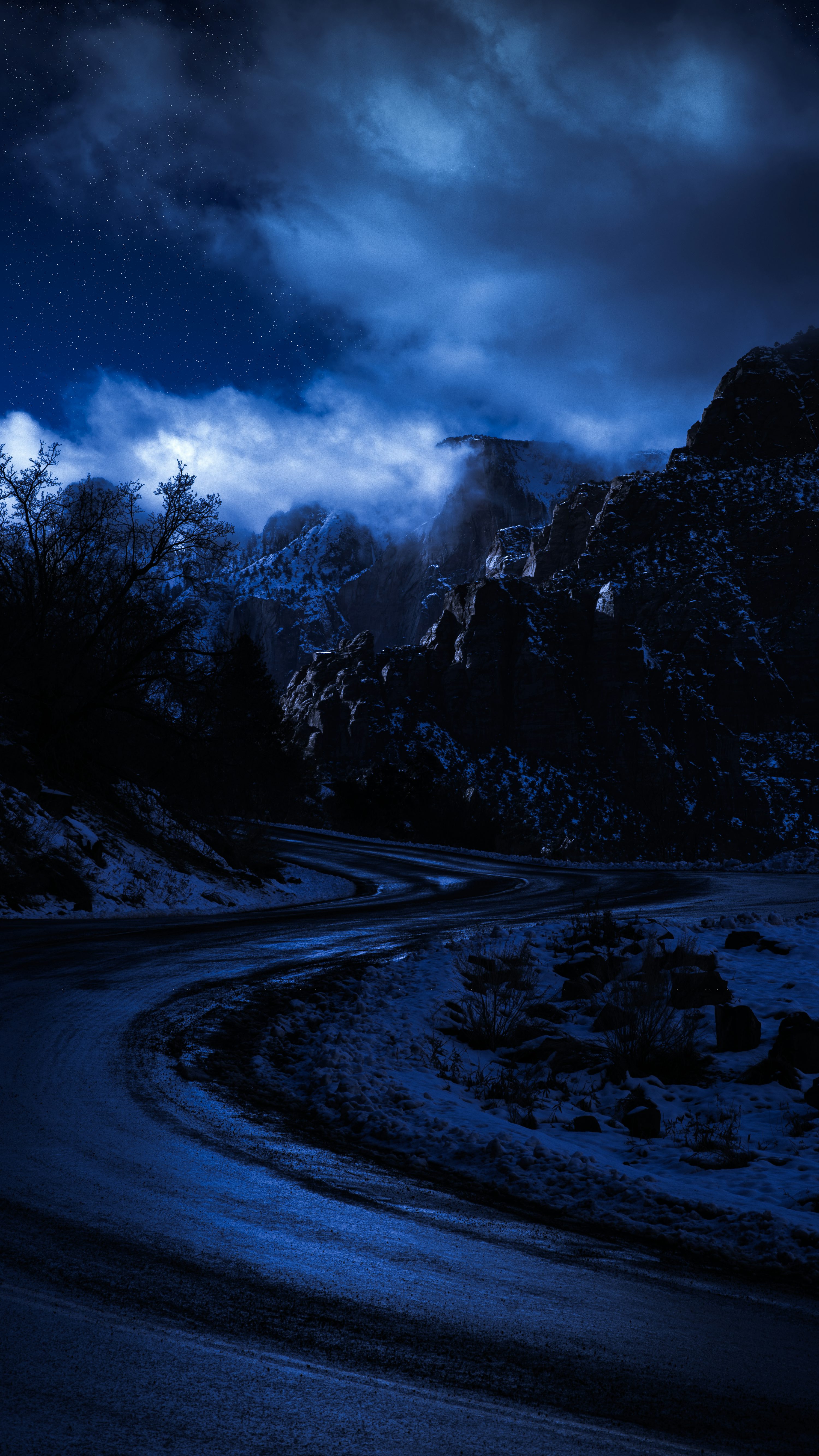 Snow covered road near trees and mountain under cloudy sky during daytime photo