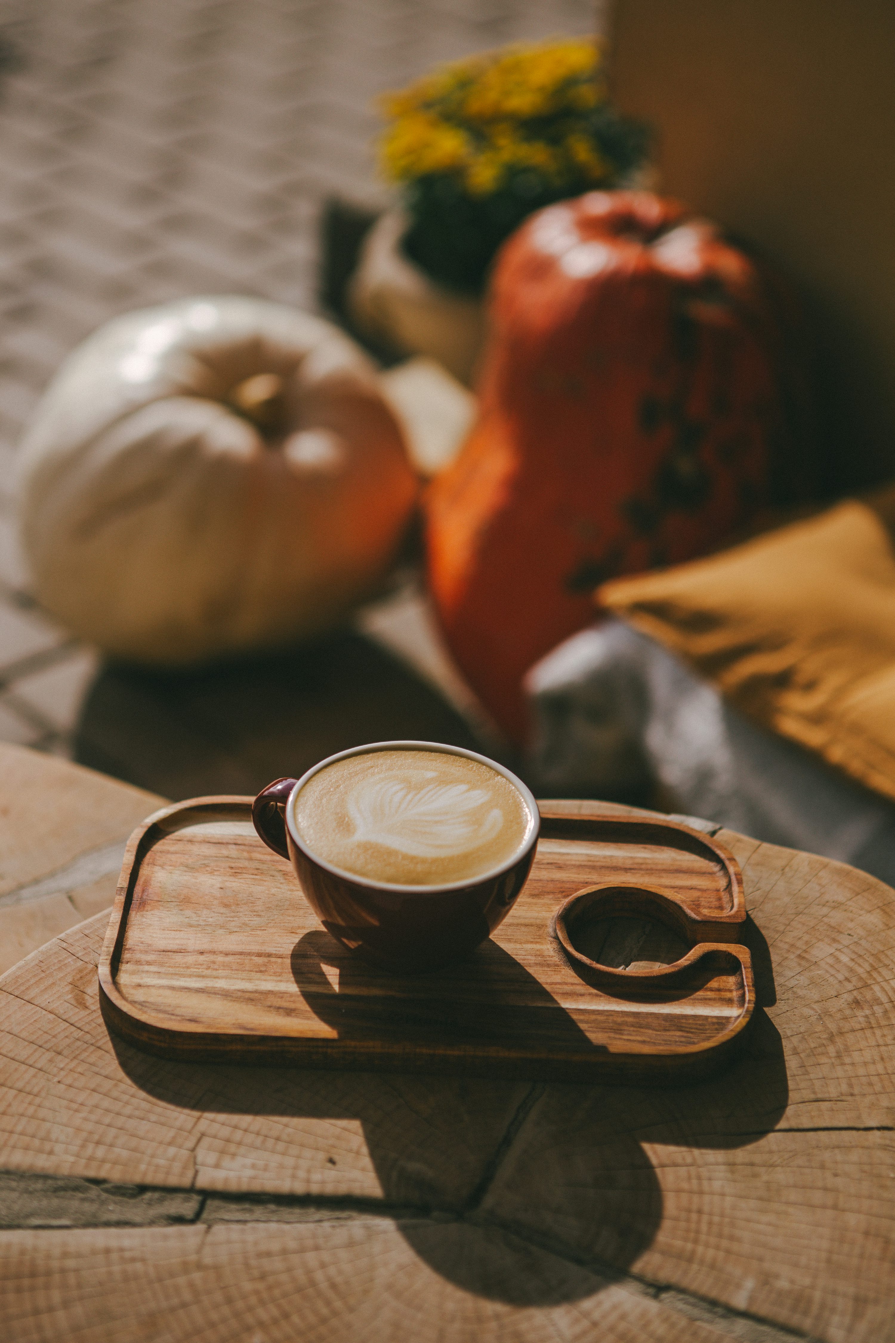 A cup of coffee sitting on top of a wooden tray photo