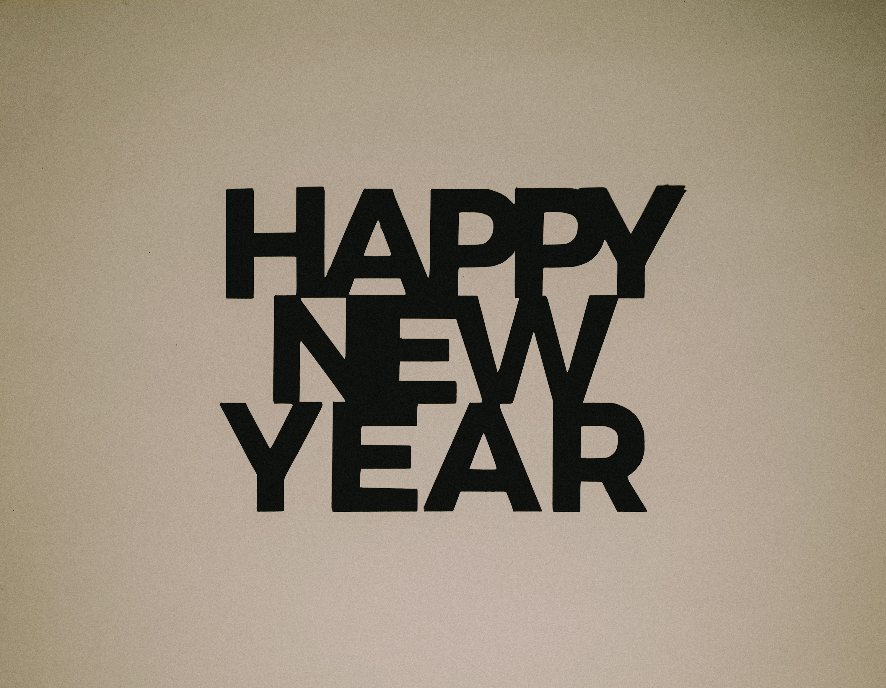 A black and white photo of a clock and a happy new year sign photo