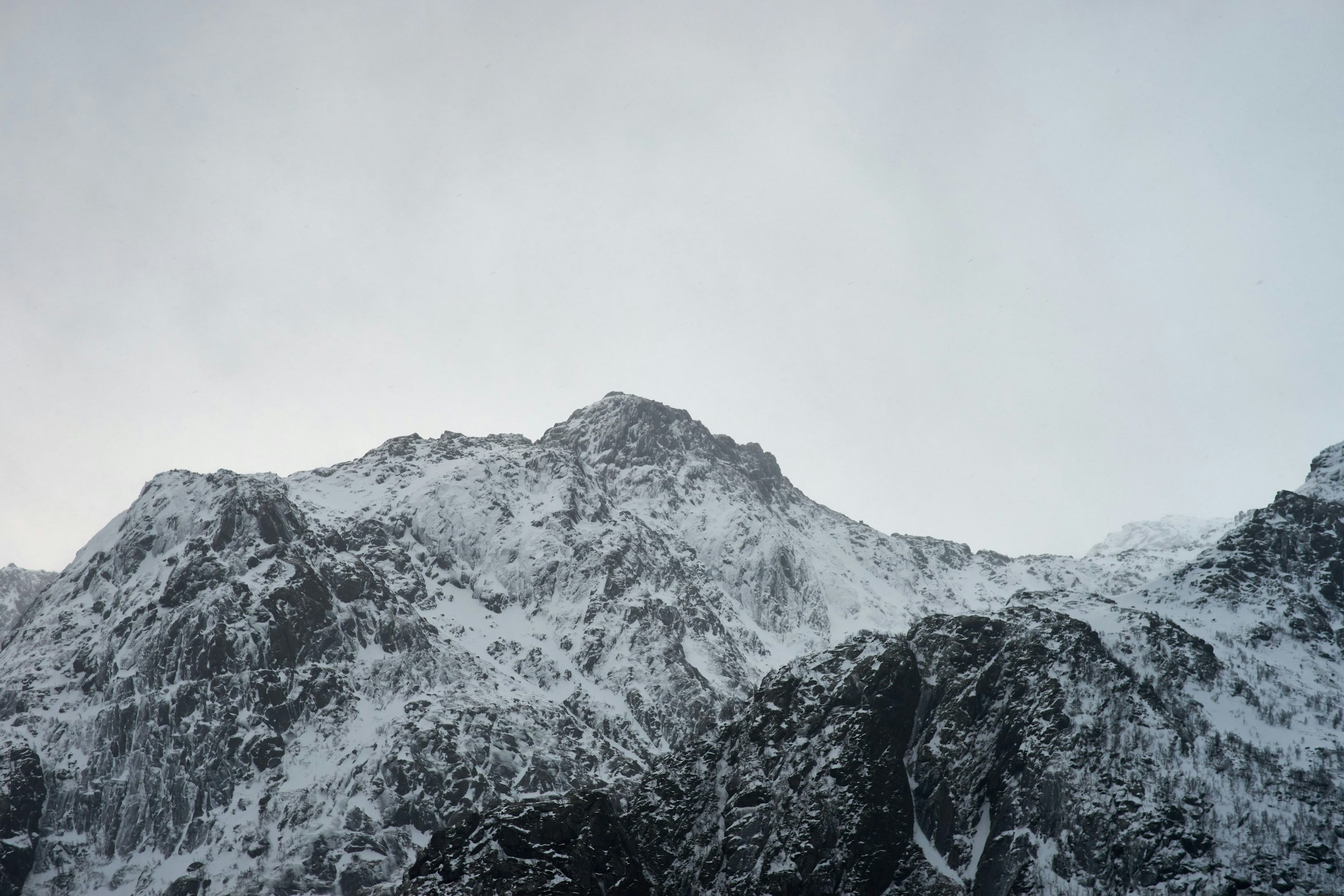 A mountain covered in snow on a cloudy day photo