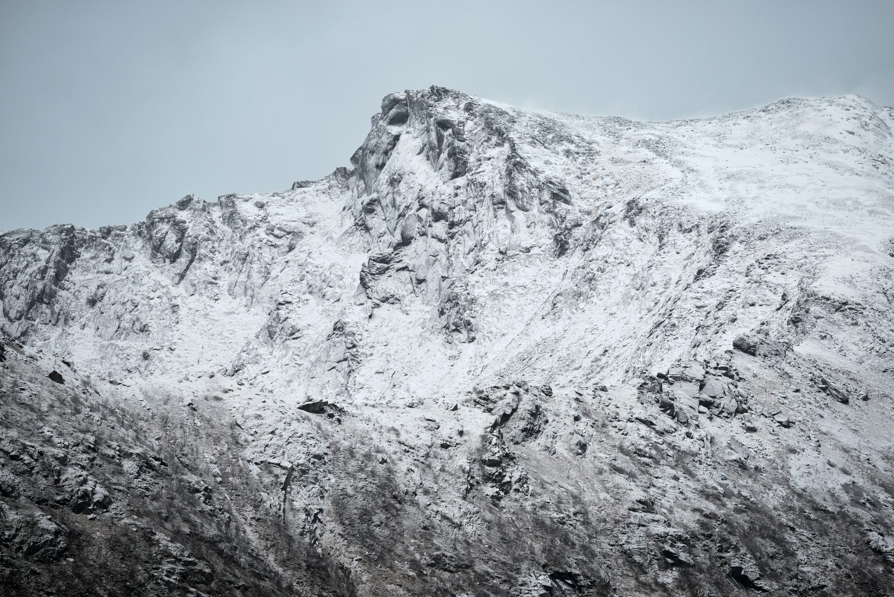 A mountain covered in snow on a cloudy day photo