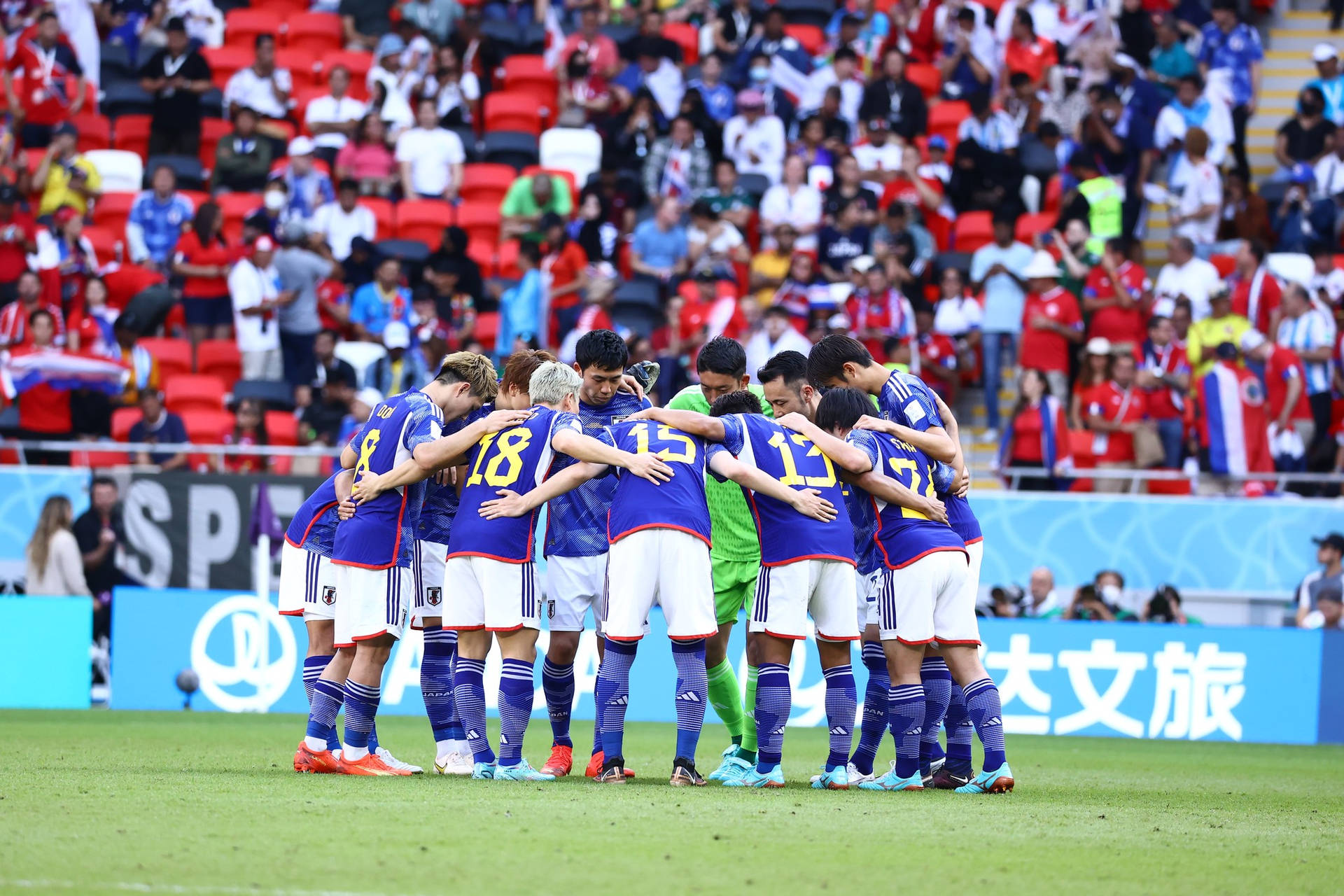 Download Determination on the Field National Football Team's Huddle Wallpaper