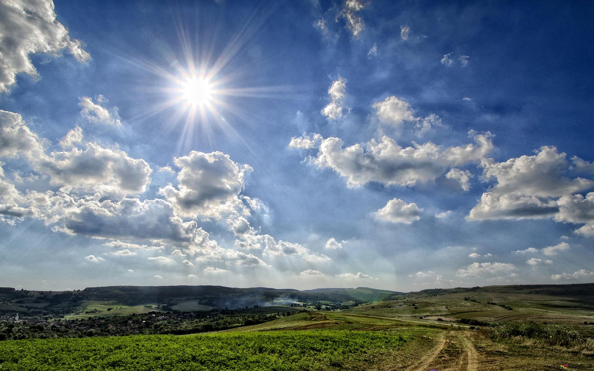 Sun majestic lights among clouds and dirt road among grass 2K wallpaper download
