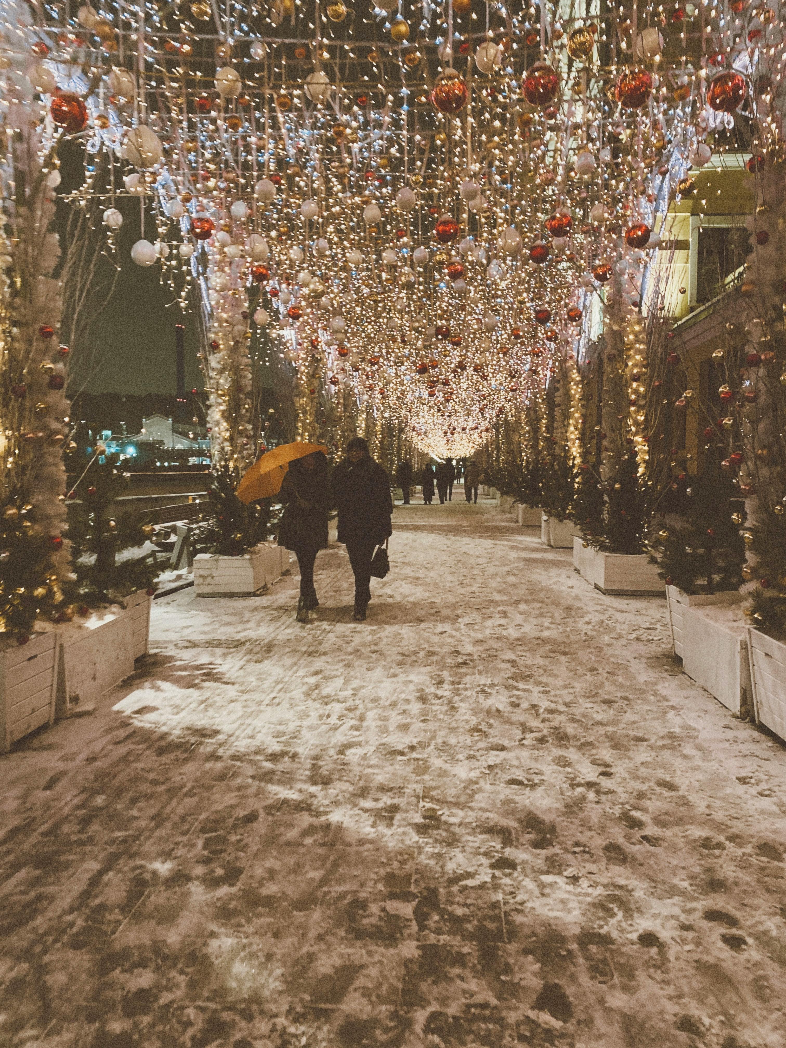 People Walking Winter Street with Lights Decoration · Free
