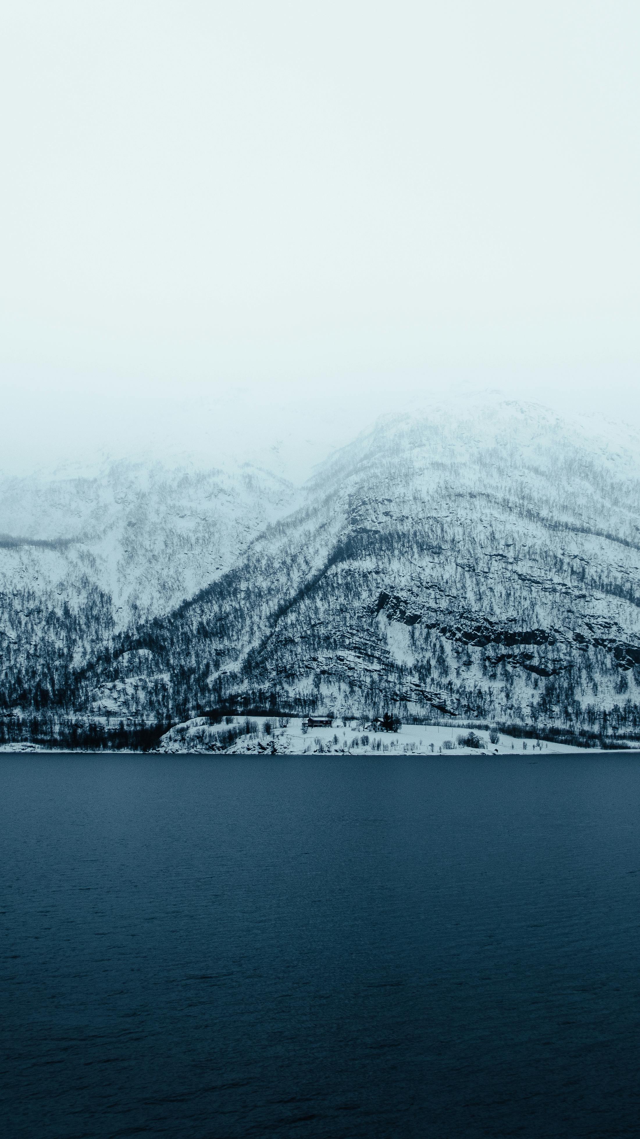 A snowy mountain range with a lake in the background · Free