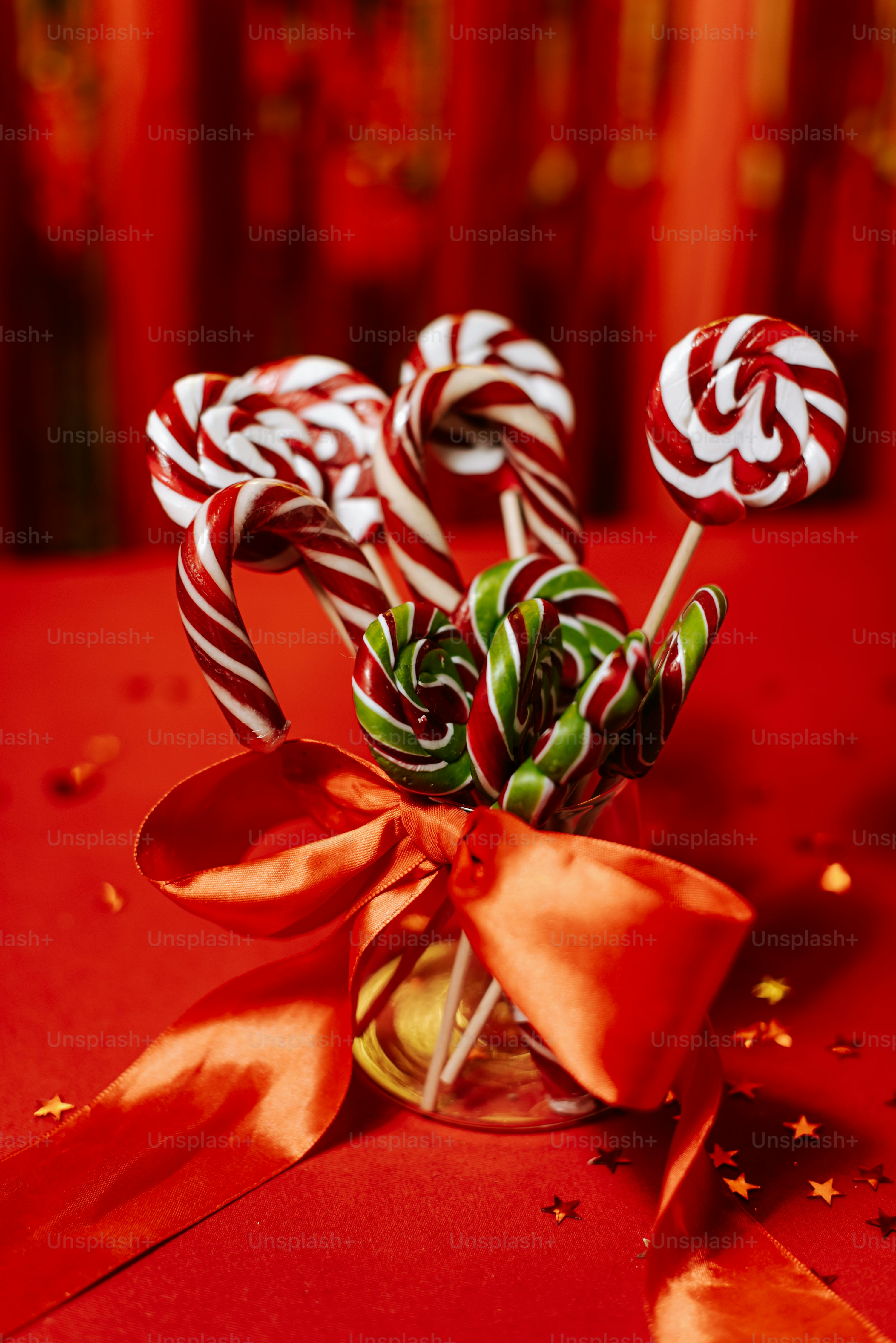 A red table topped with candy canes and a bow photo