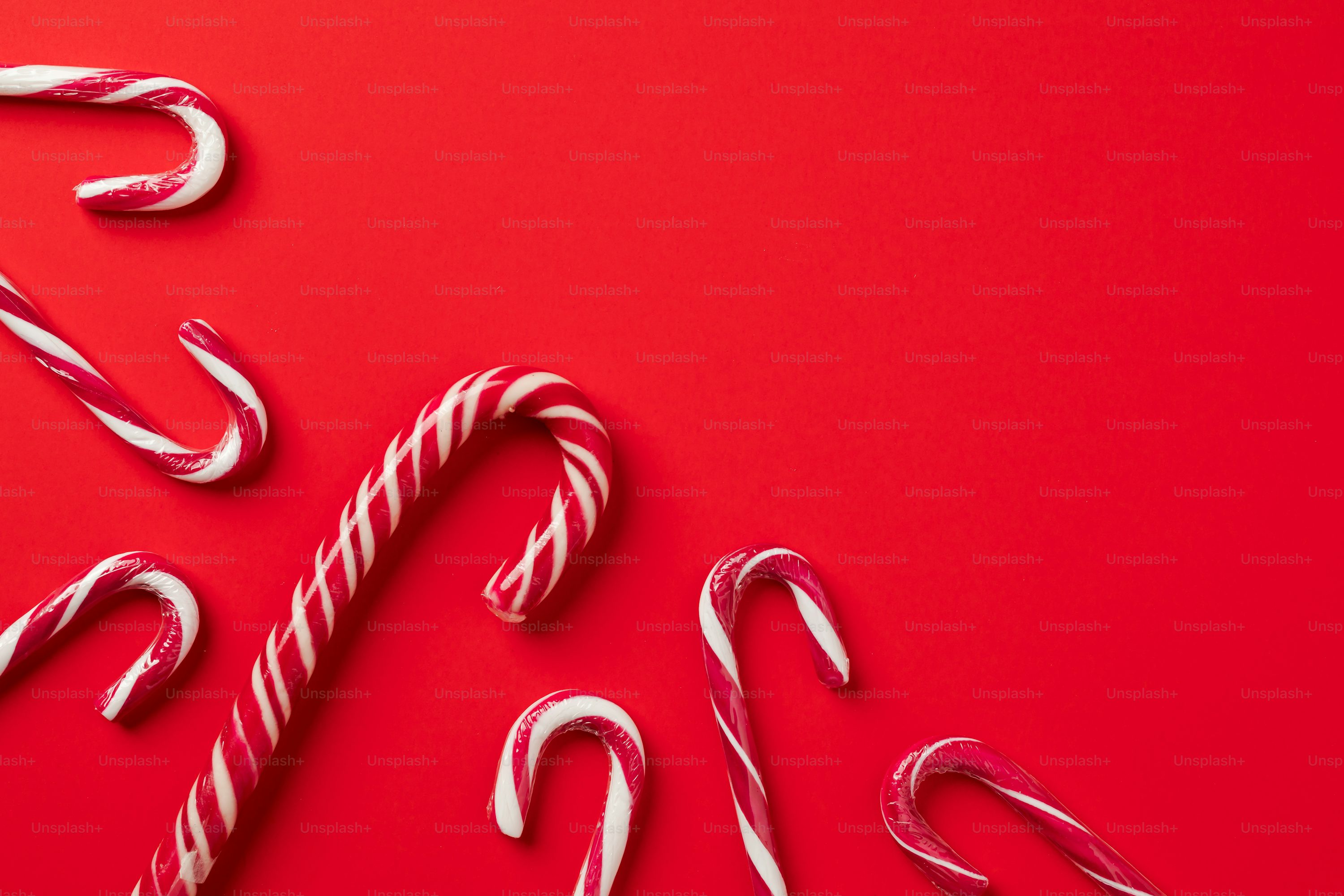 A candy cane and two candy canes on a red background photo