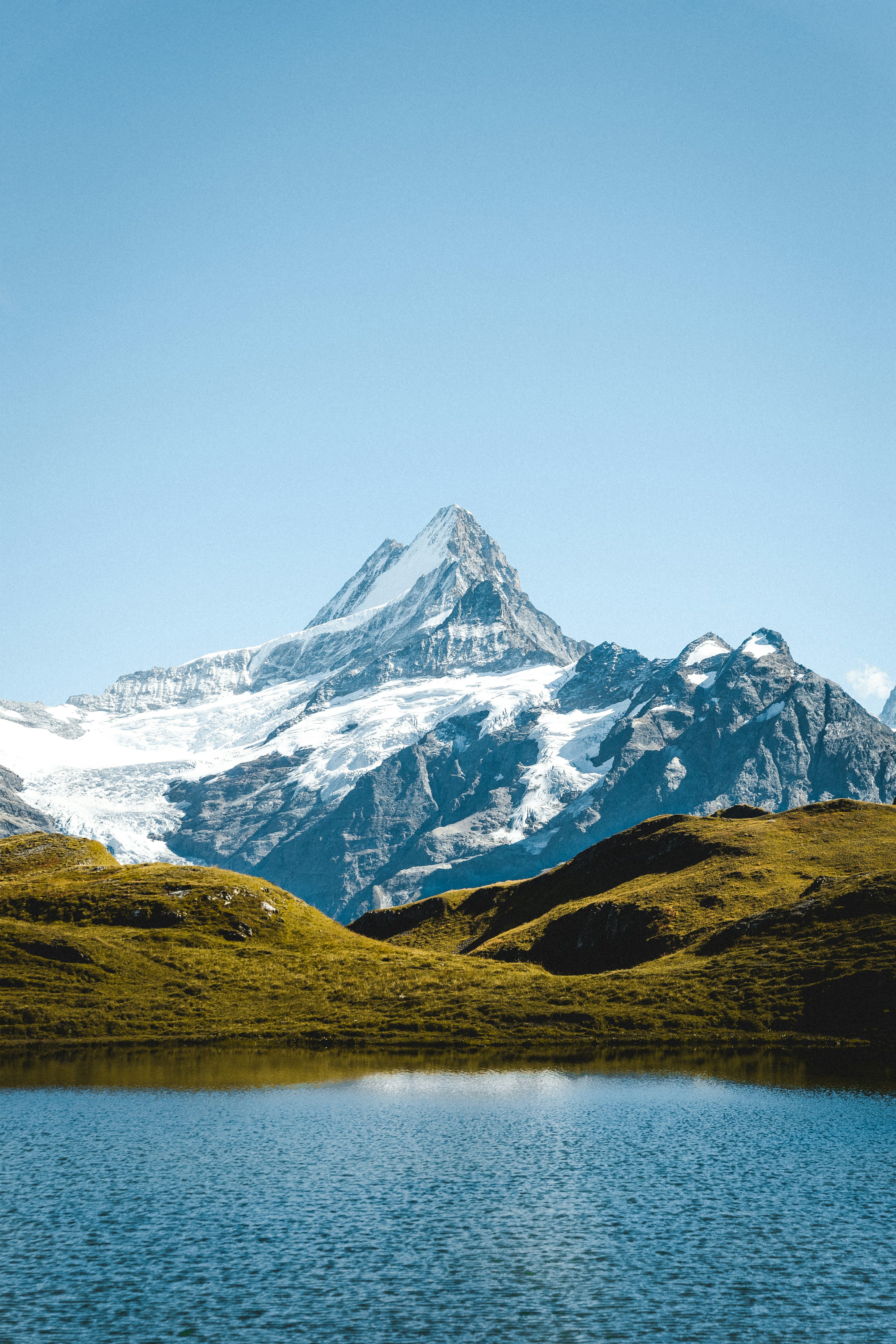 Snow Capped Mountain Peak Reflected In A Calm Lake. Photo