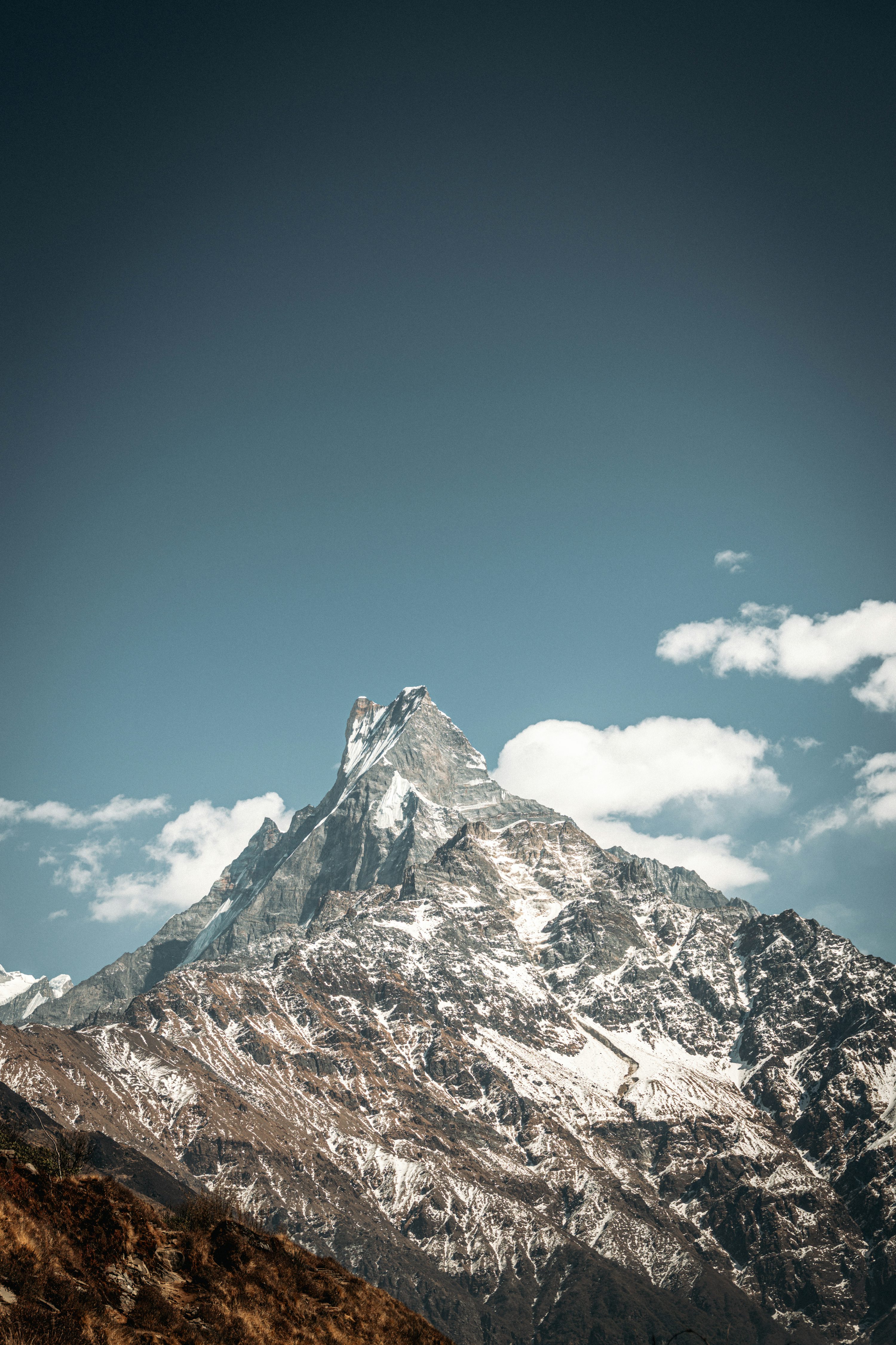 Snow Capped Mountain Peak Under A Clear Blue Sky Photo