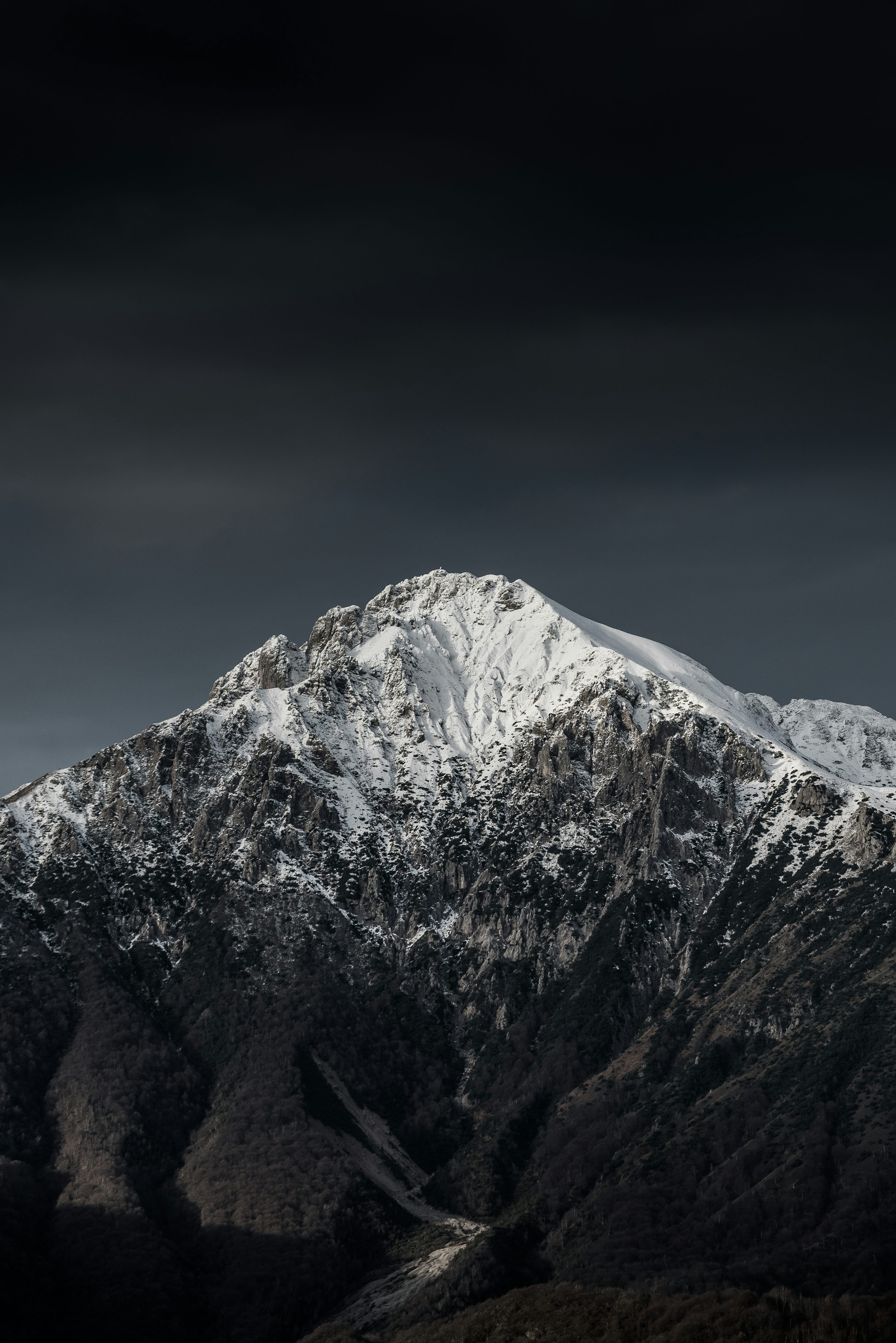 Snow capped mountain under cloudy sky photo