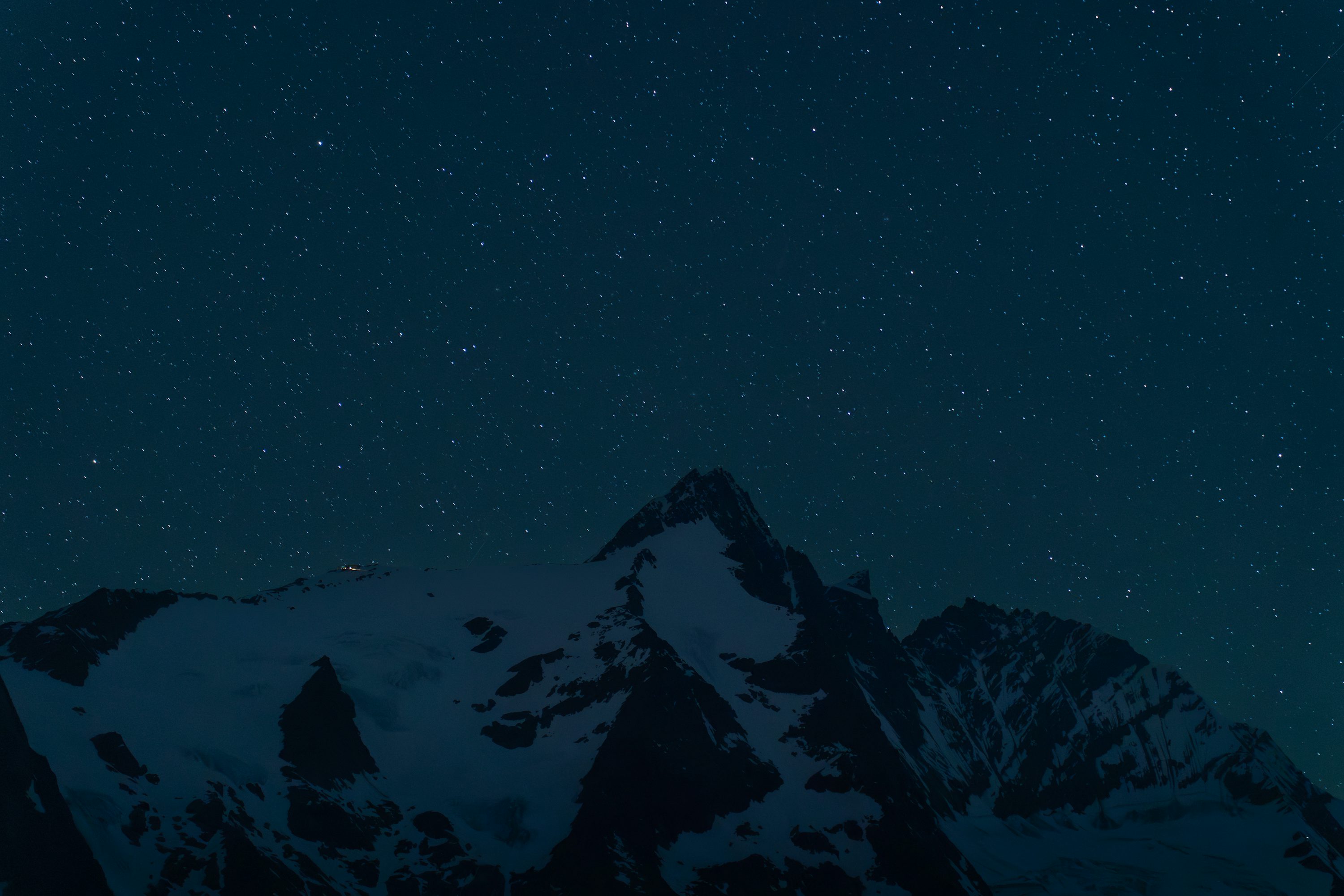 Snowy mountain peak under a starry night sky photo