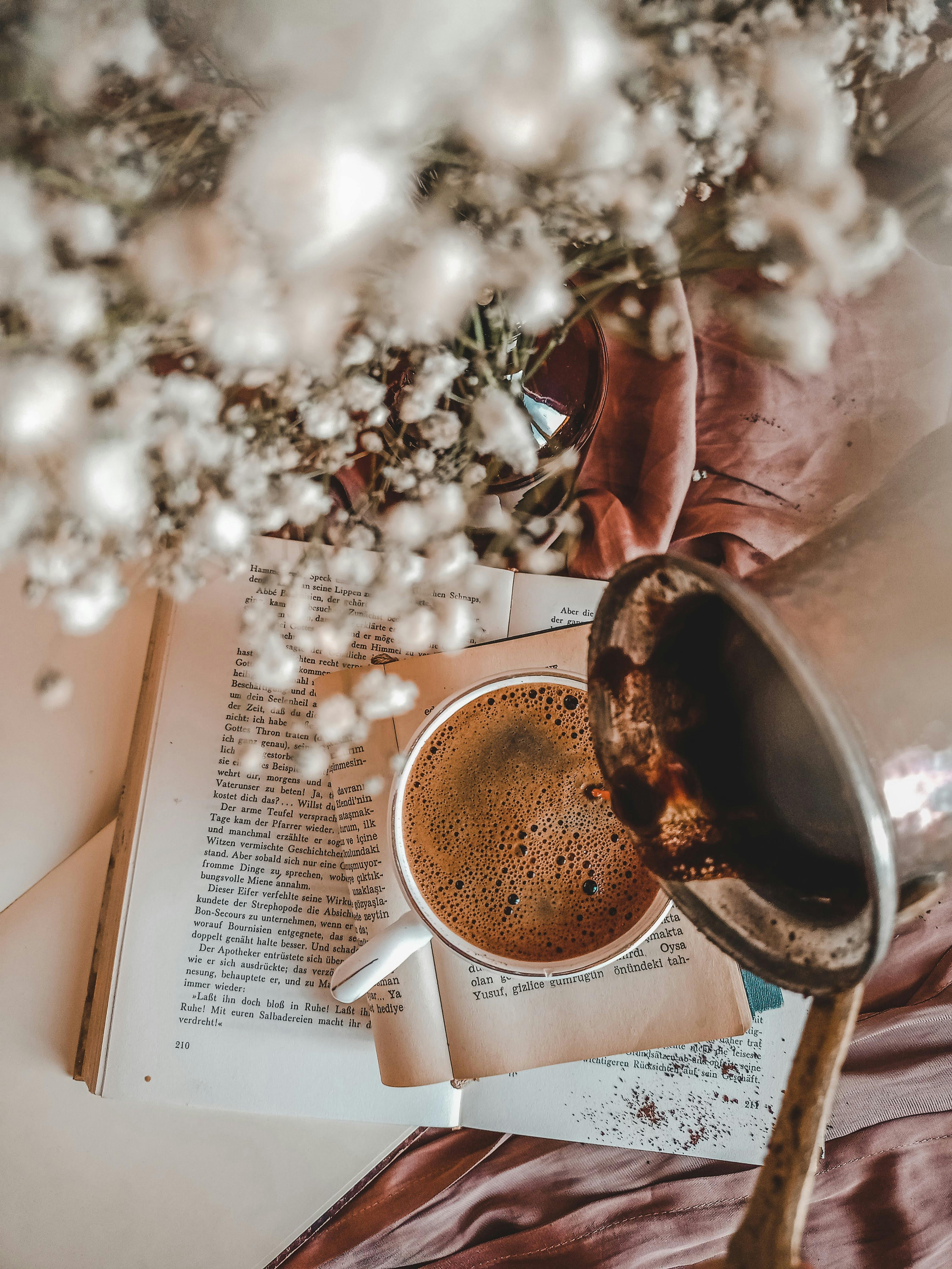 Pouring Coffee into Cup on Book Page · Free