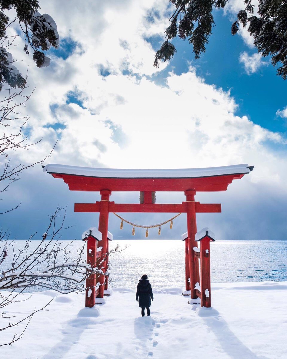 Look at this stunning view of Lake Tazawa seenght red torii gate! ⛩️❄️ On a clear day, the red of the gate makes a beautiful contrast with the deep