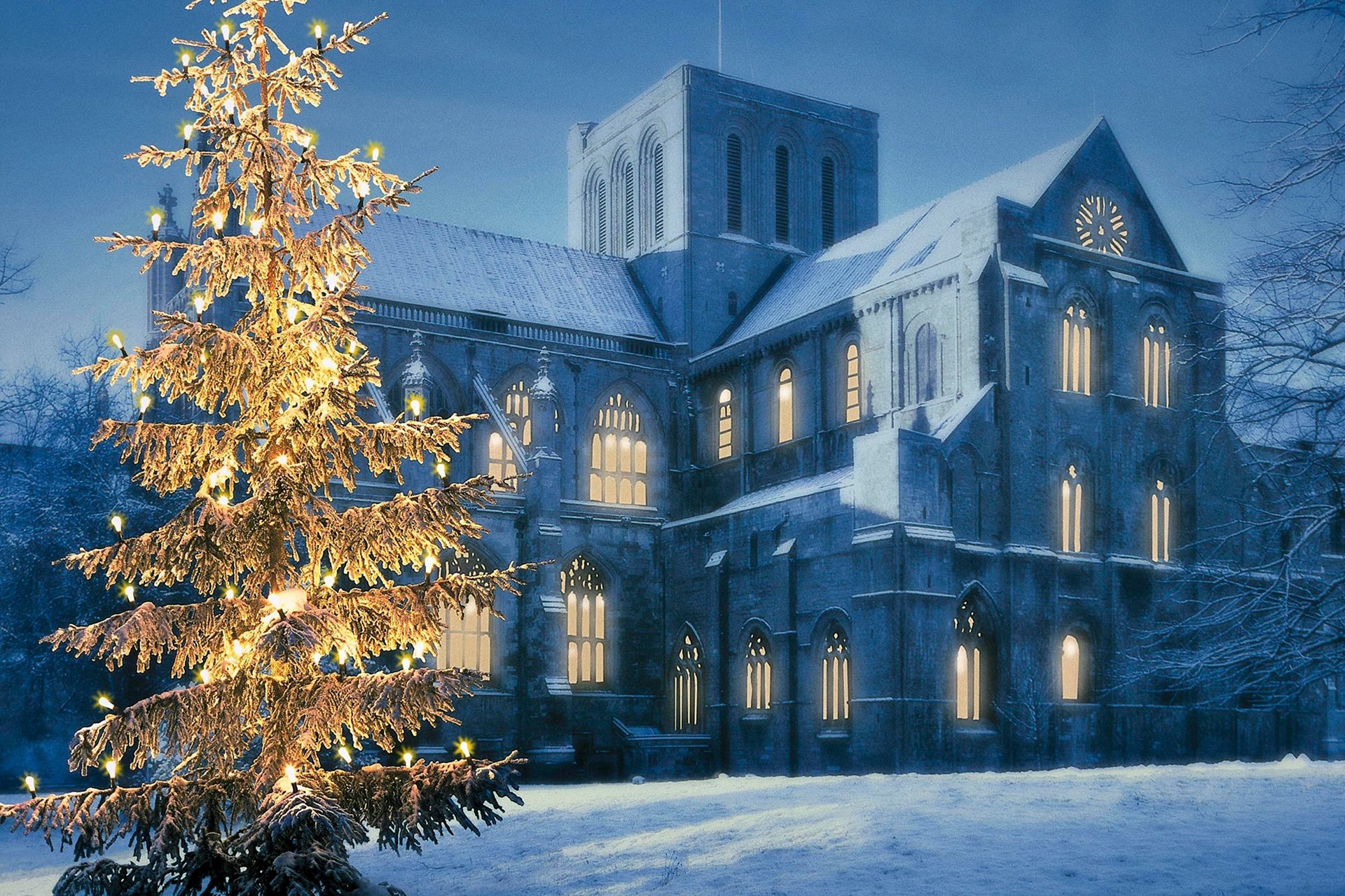 Winter Glow: Christmas Tree and Church in Snowy Night HD Wallpaper