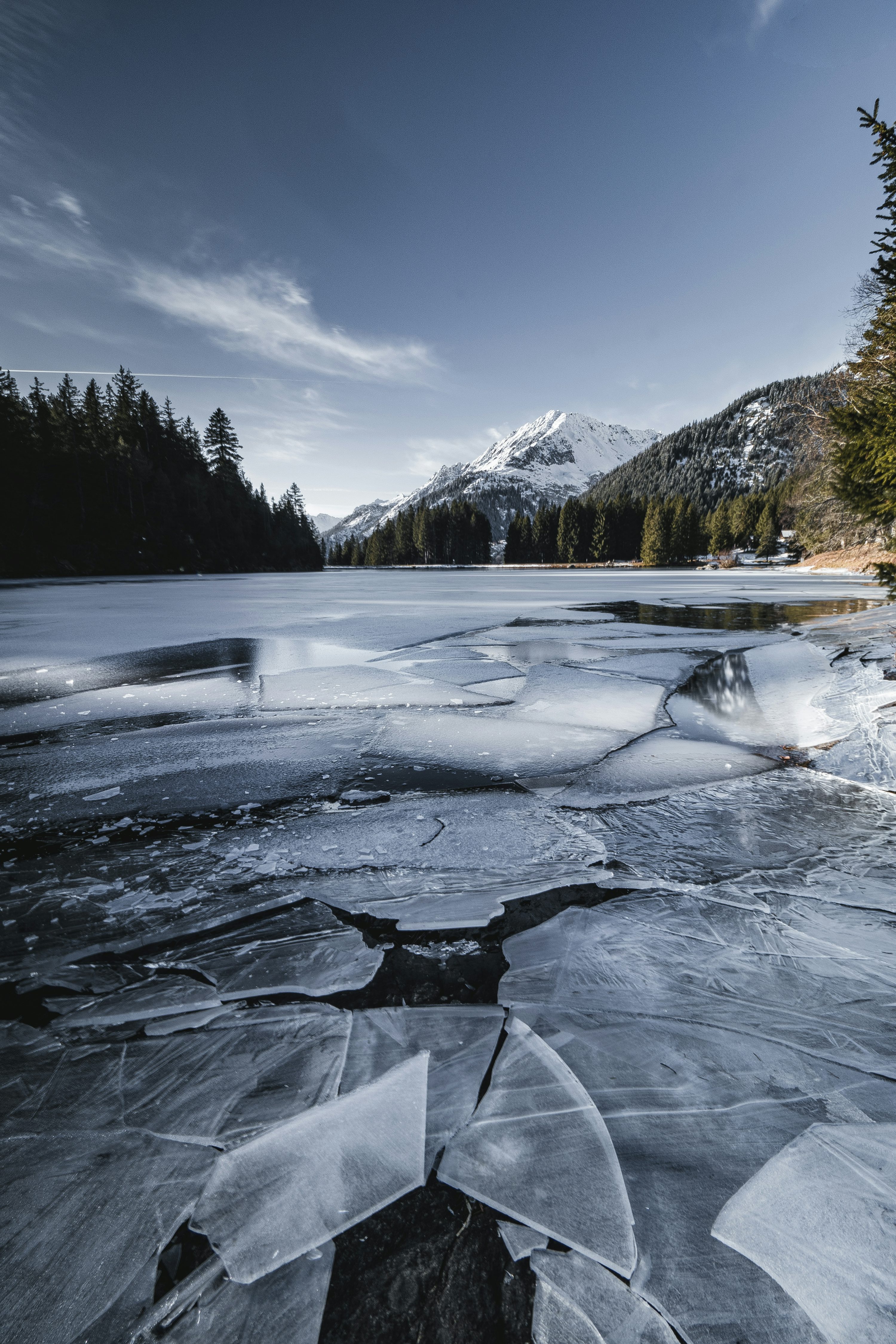 A frozen lake with trees and mountains in the background photo