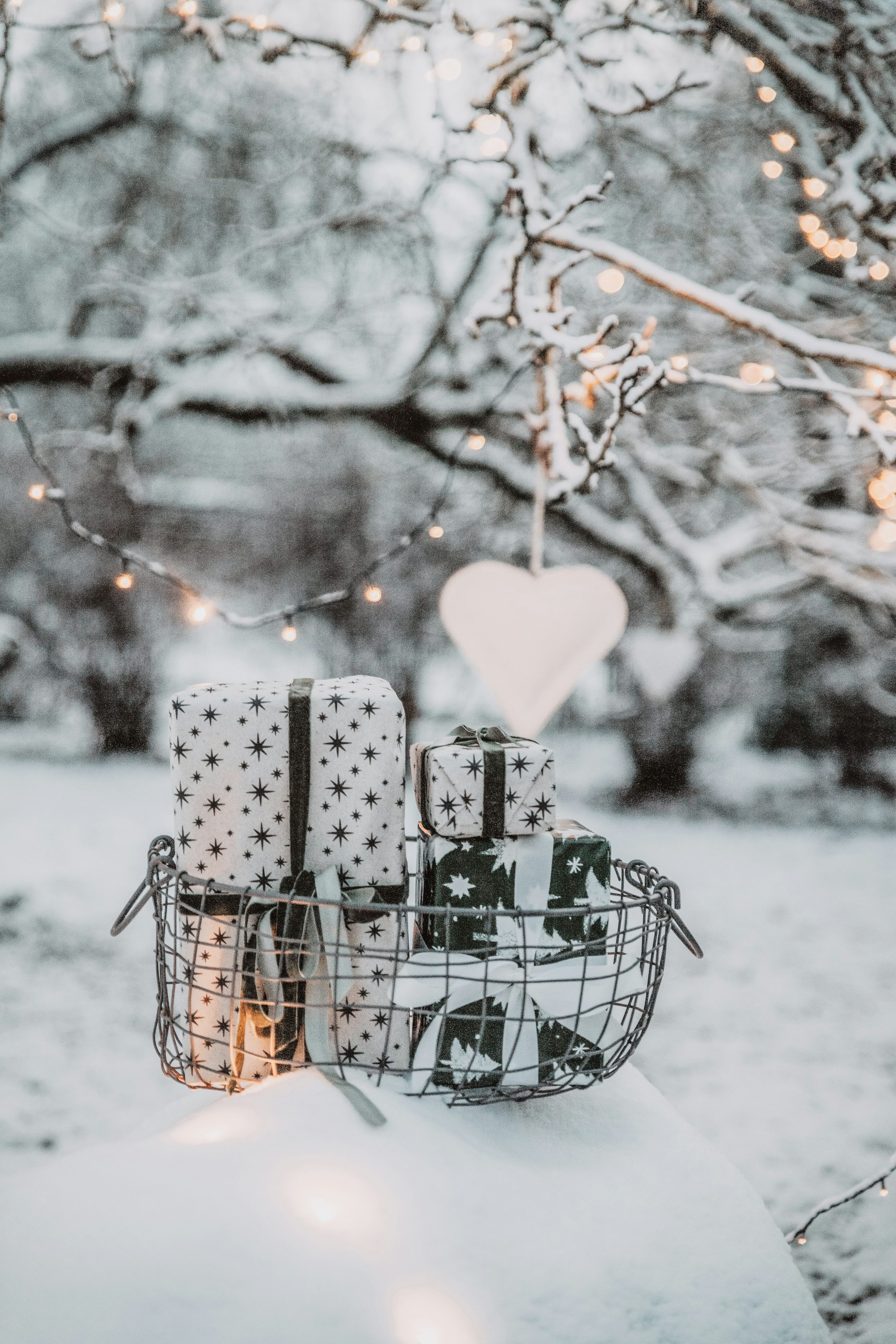 A basket filled with wrapped presents sitting on top of a snow covered ground photo