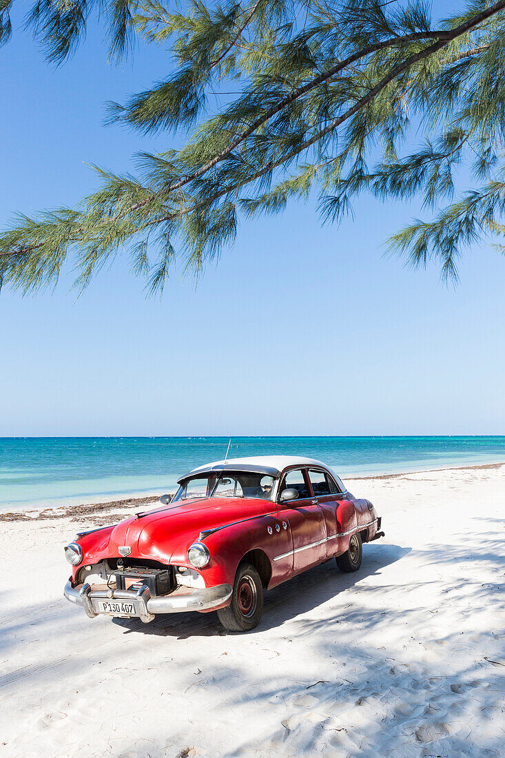 Red oldtimer on the beach of Cayo