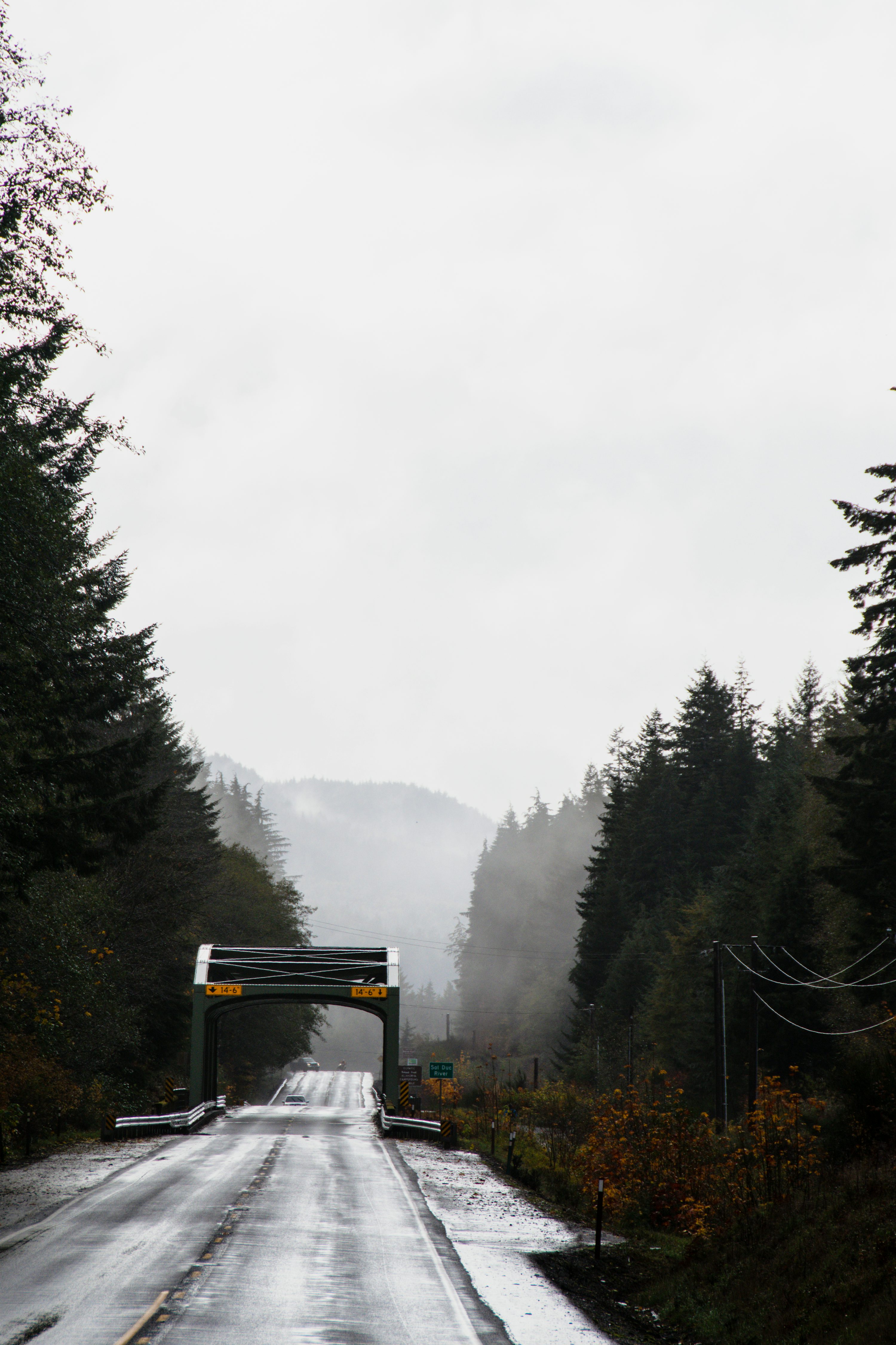 A road with snow on the ground next to a body of water photo