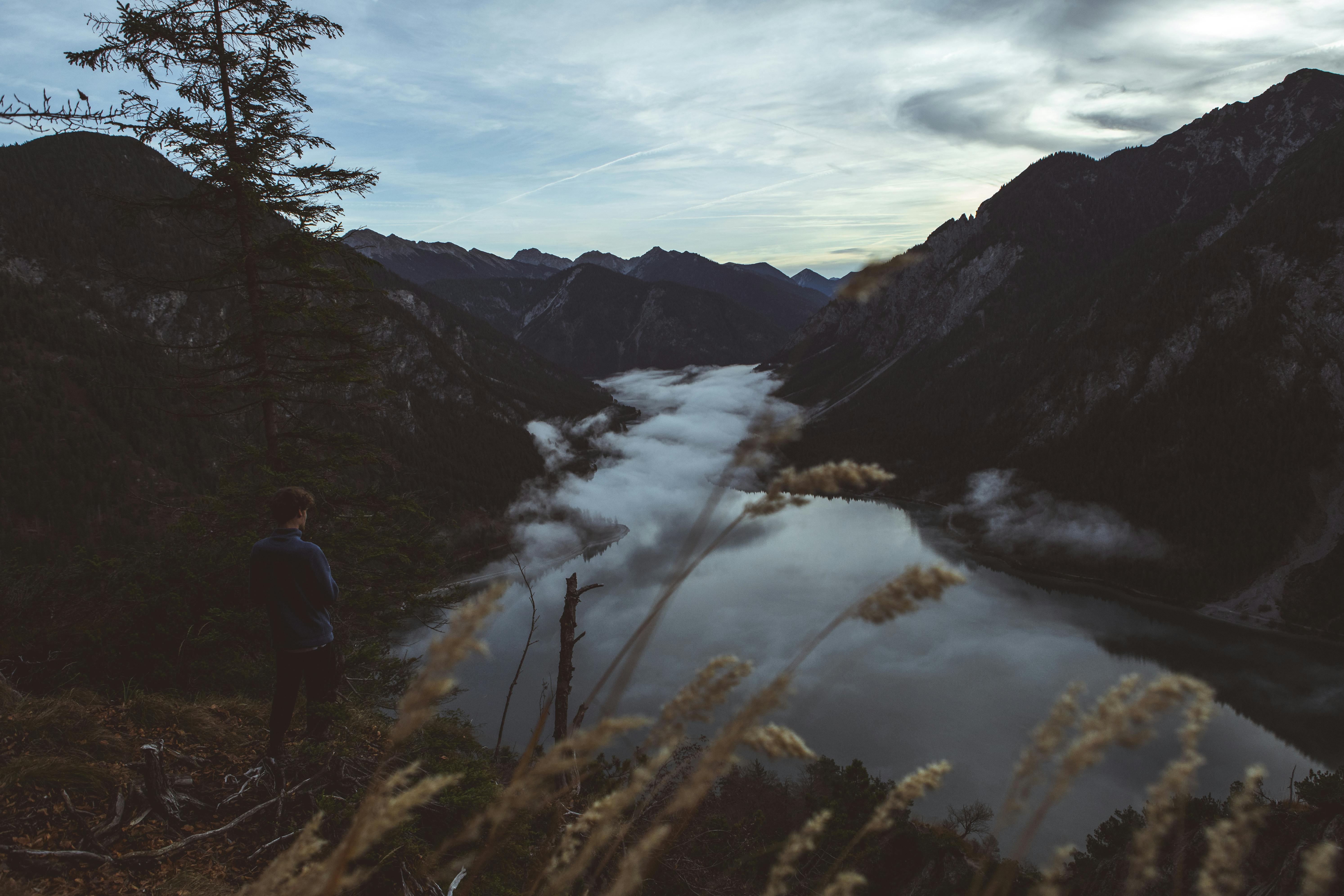 Unrecognizable woman sitting on hill · Free