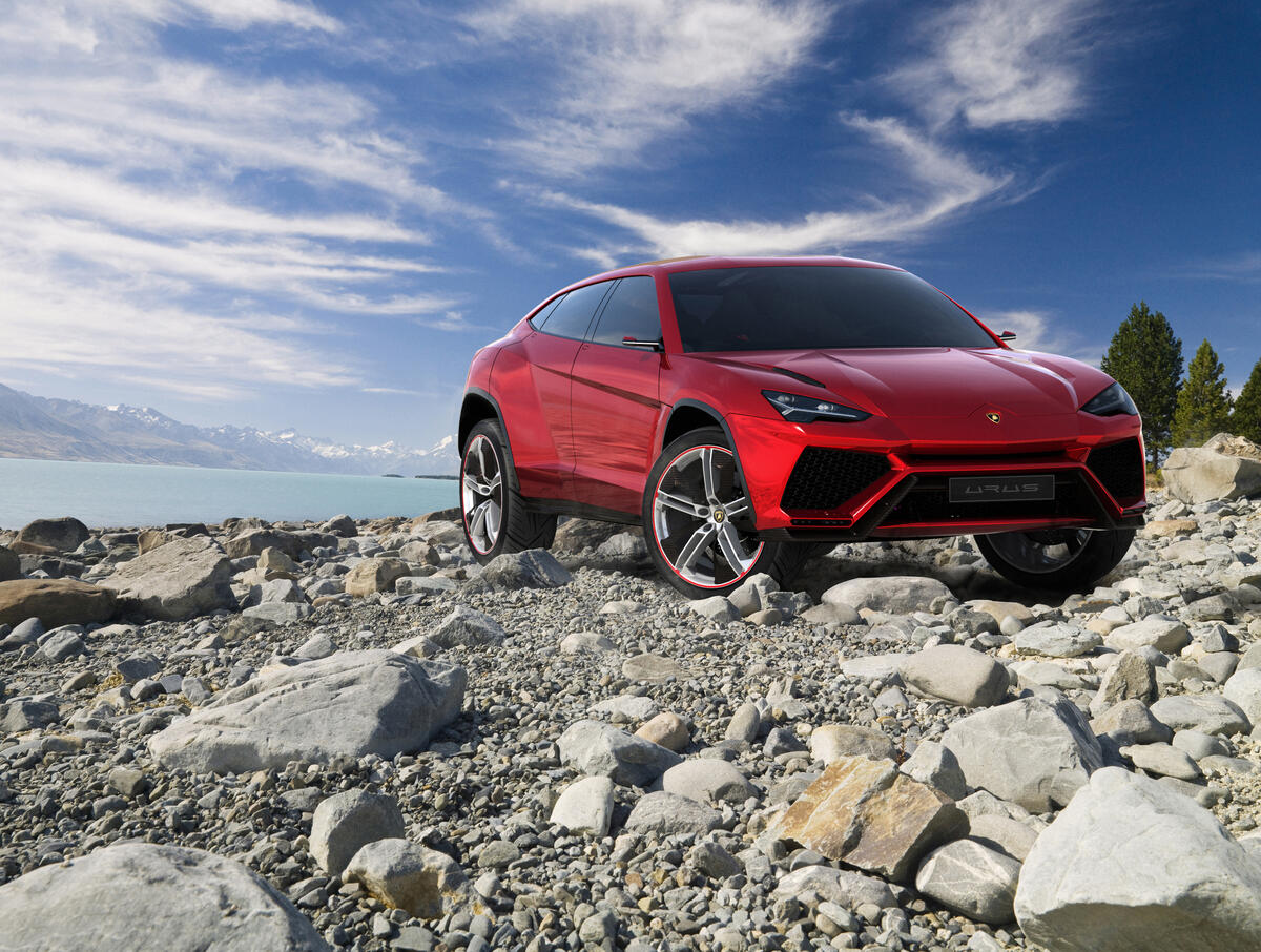 The red Lamborghini Urus drives over sharp rocks. · free photo from uaha and wallpaper