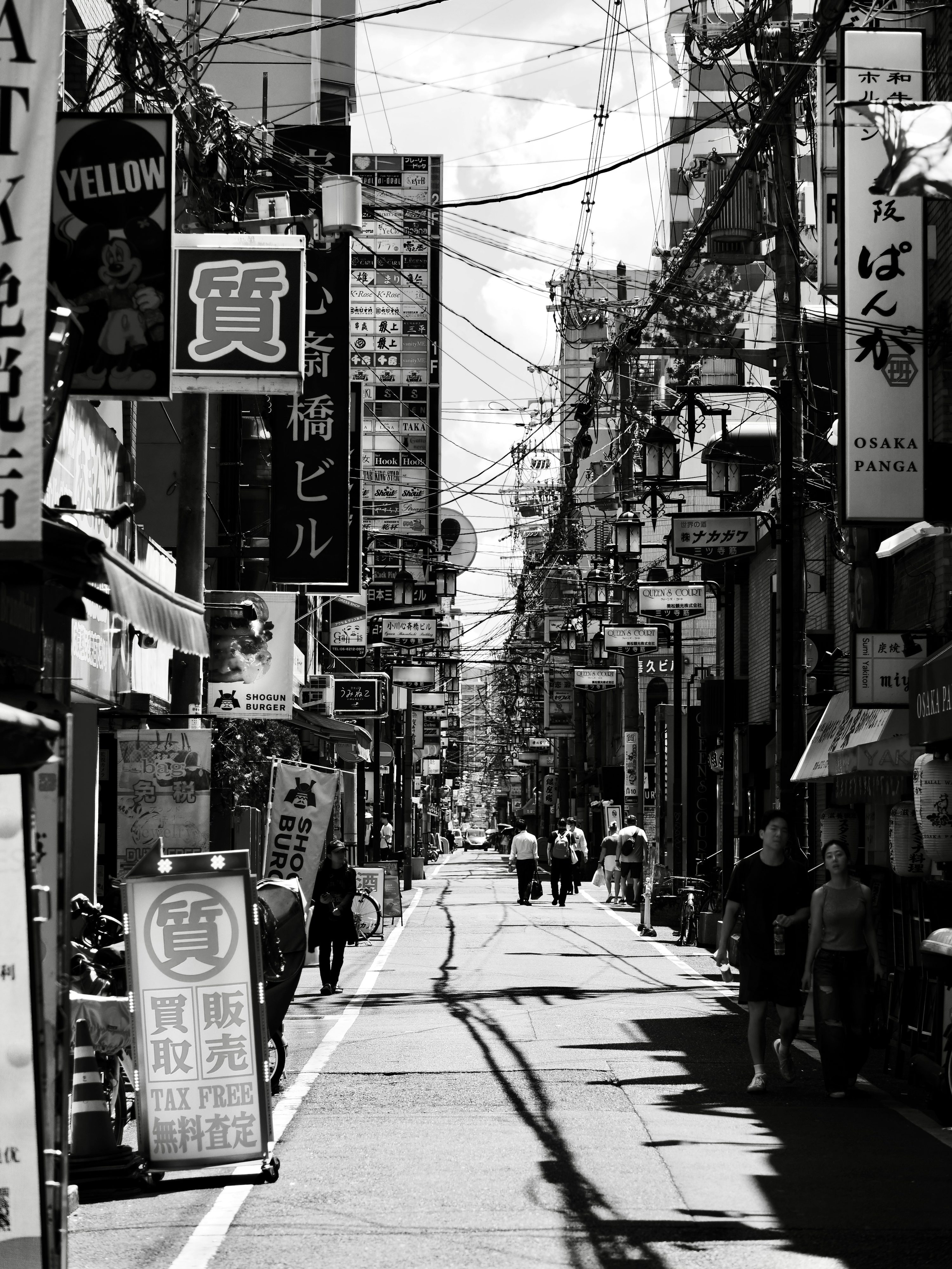 A narrow street in japan with signs and people. photo