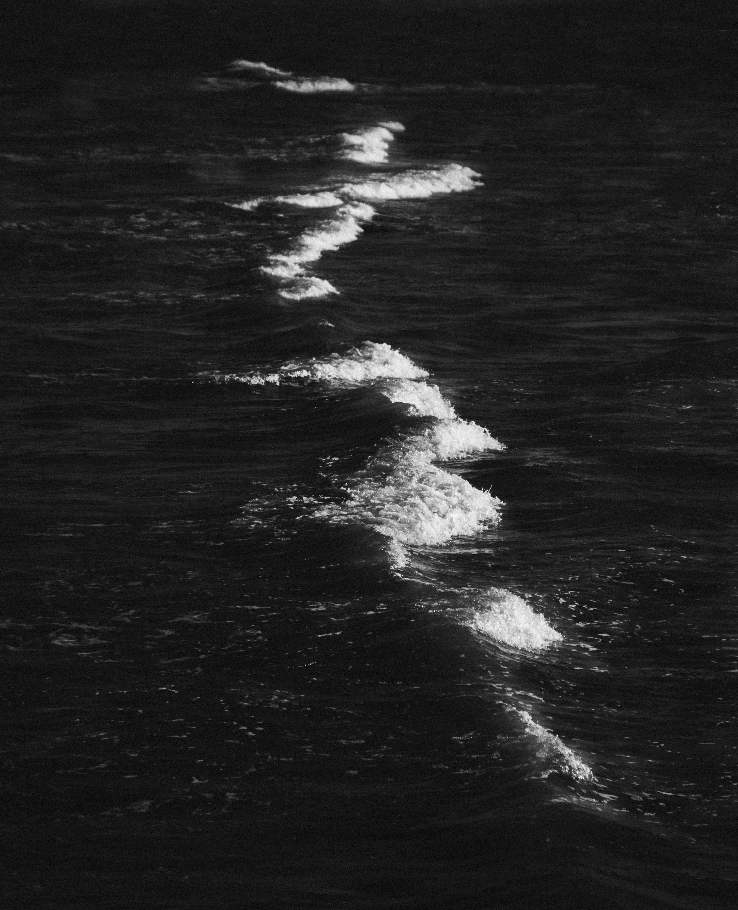 A black and white photo of waves in the ocean photo