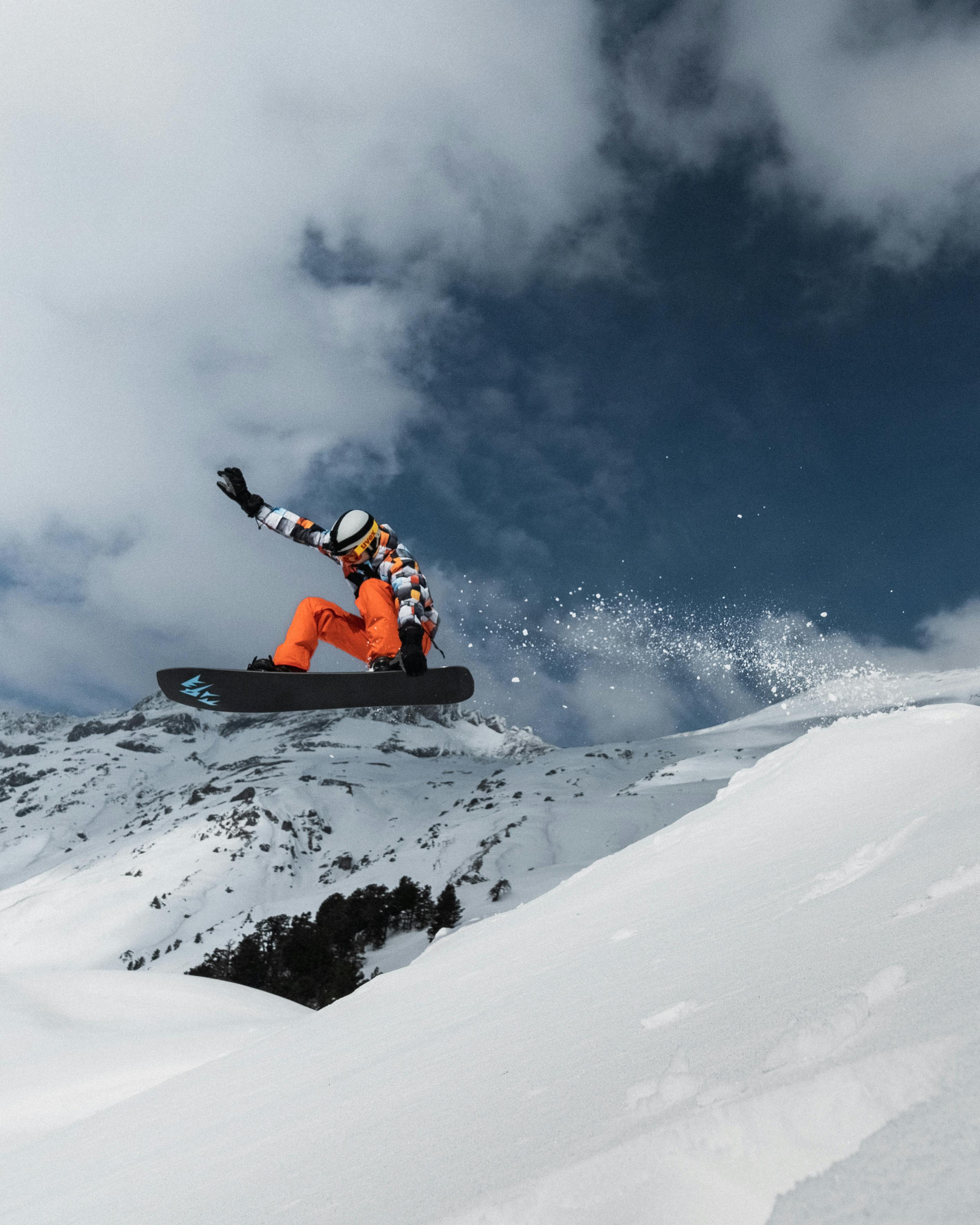 A Person Snowboarding On A Snow Covered Hill · Free