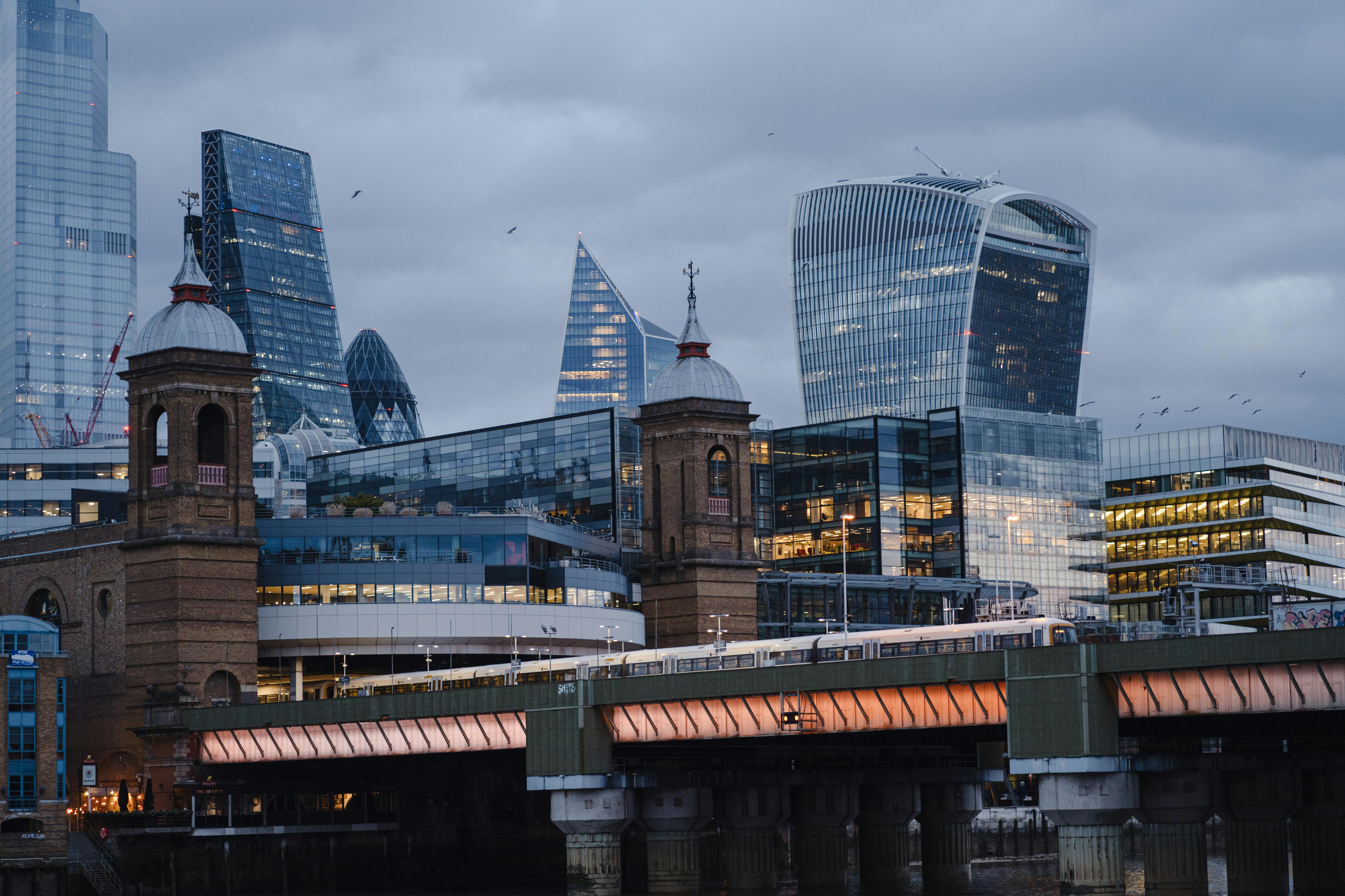 Contemporary financial buildings near suspension bridge · Free