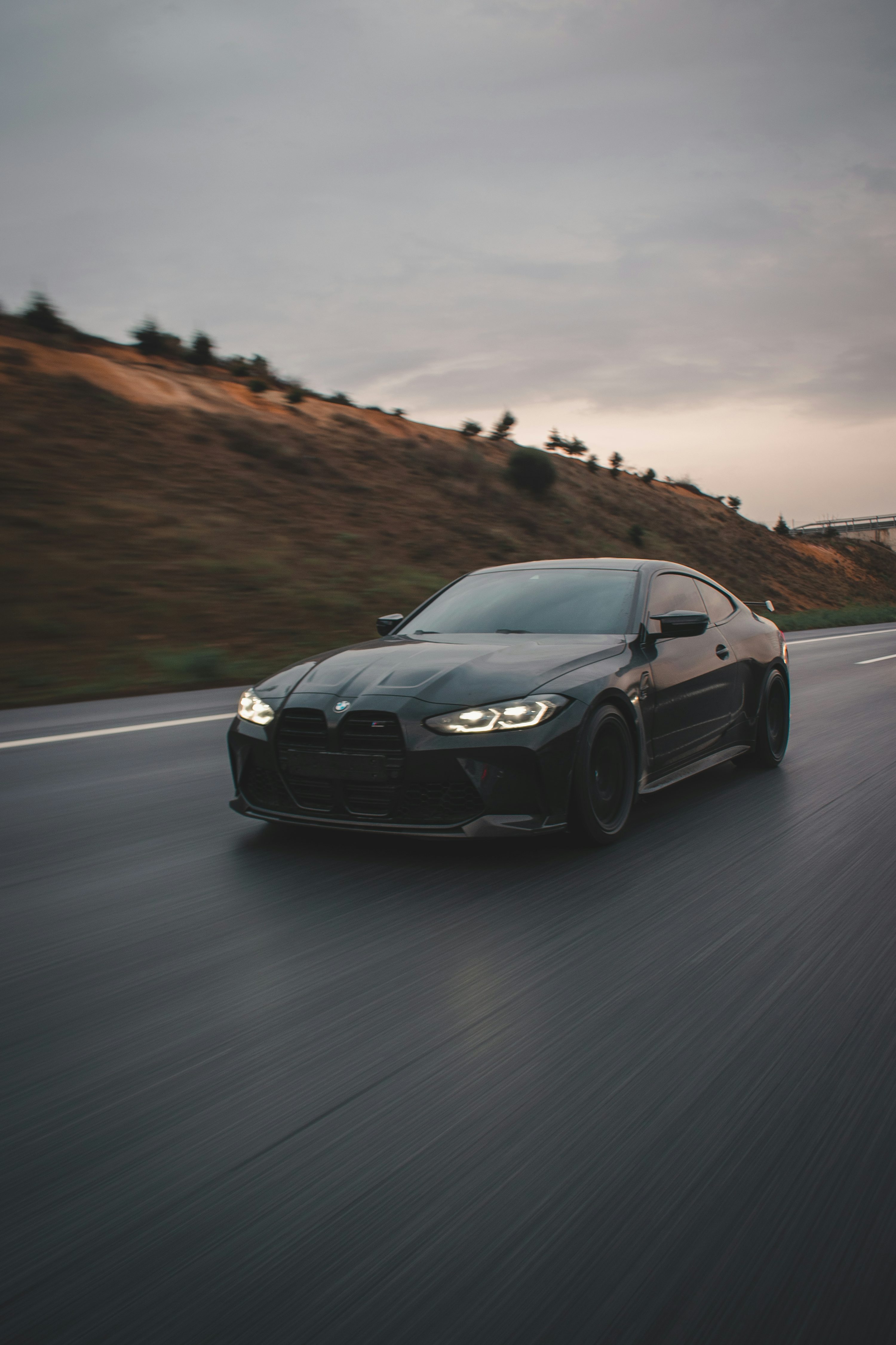 A black sports car driving down the road photo