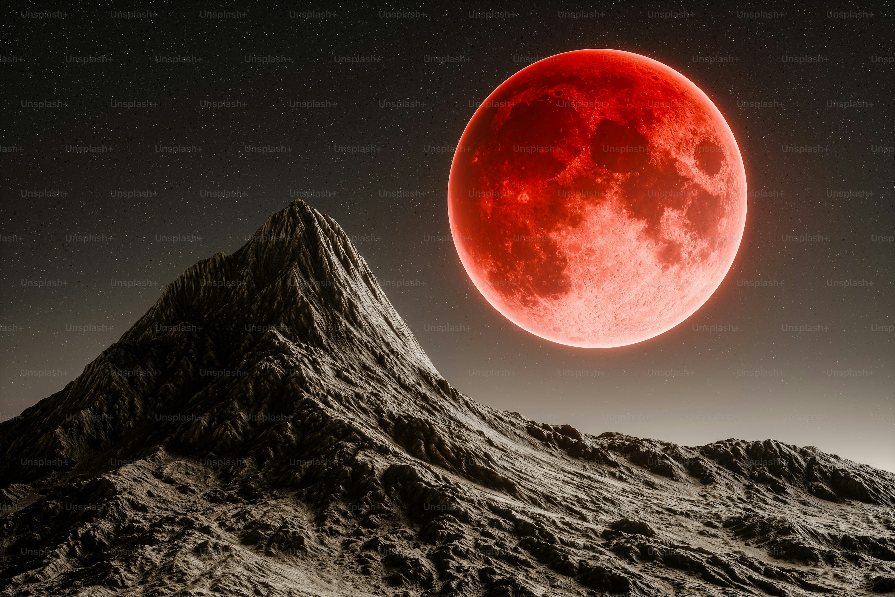 A red moon is seen over a mountain photo