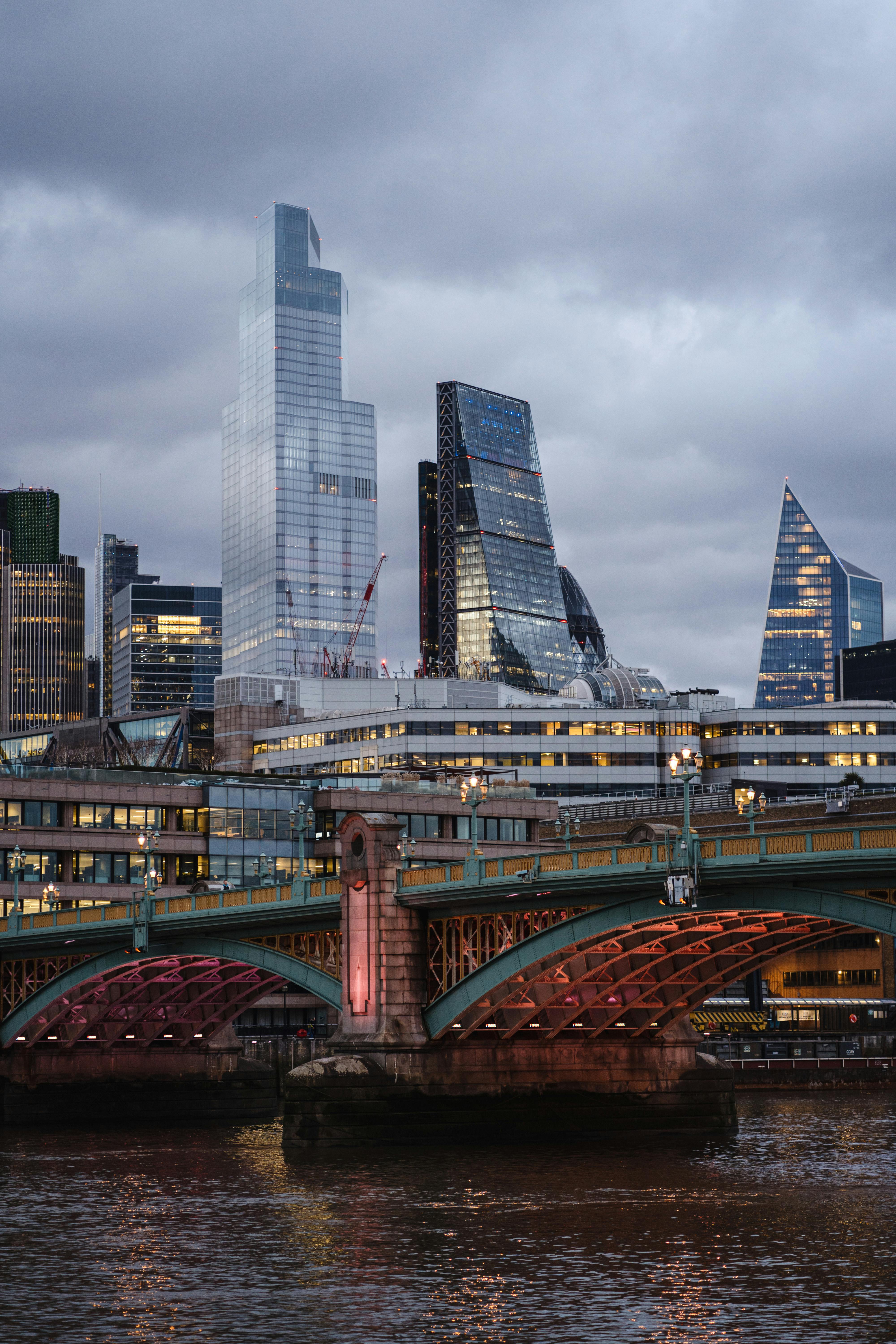 Contemporary financial buildings near suspension bridge · Free