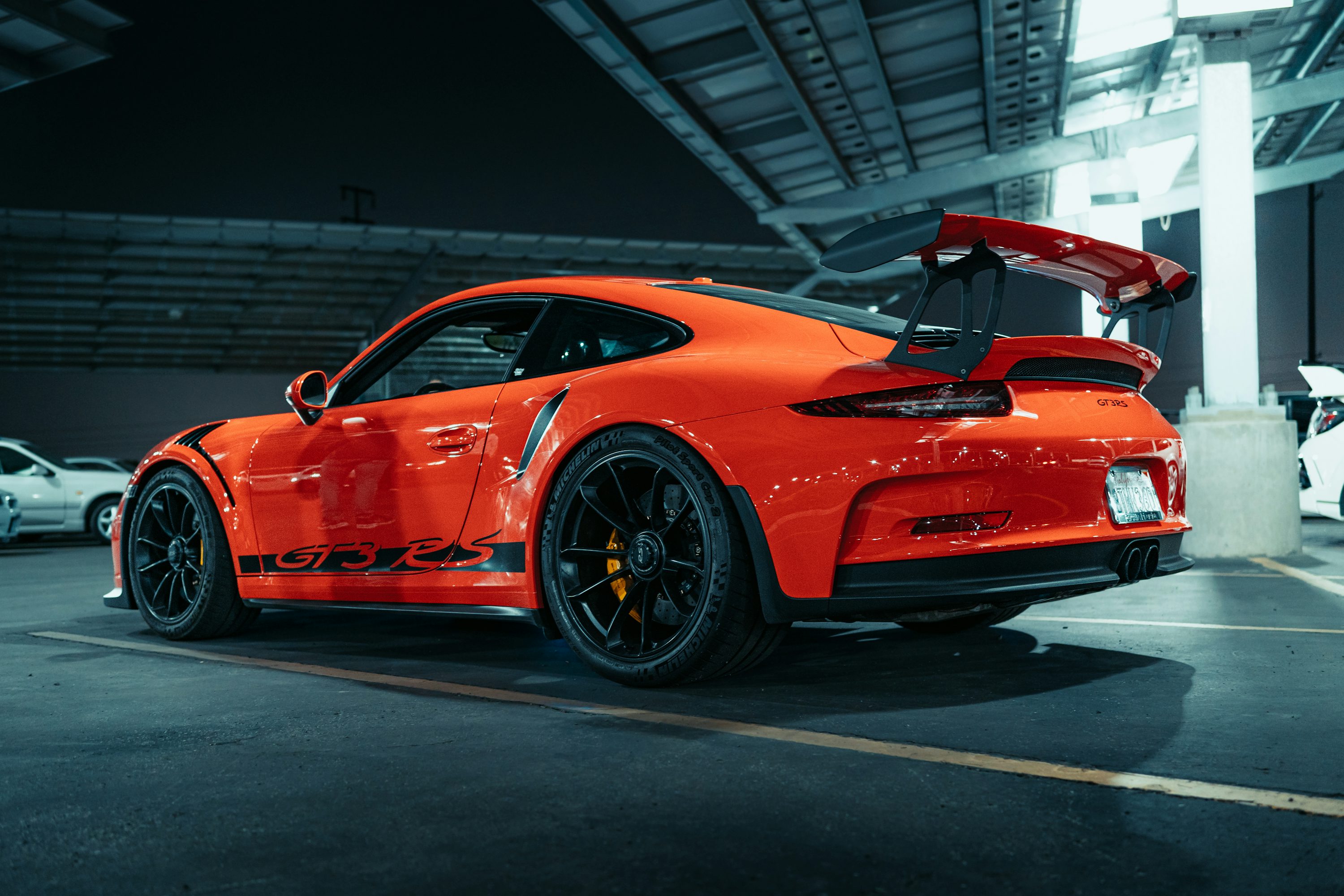 An orange sports car parked in a parking lot photo