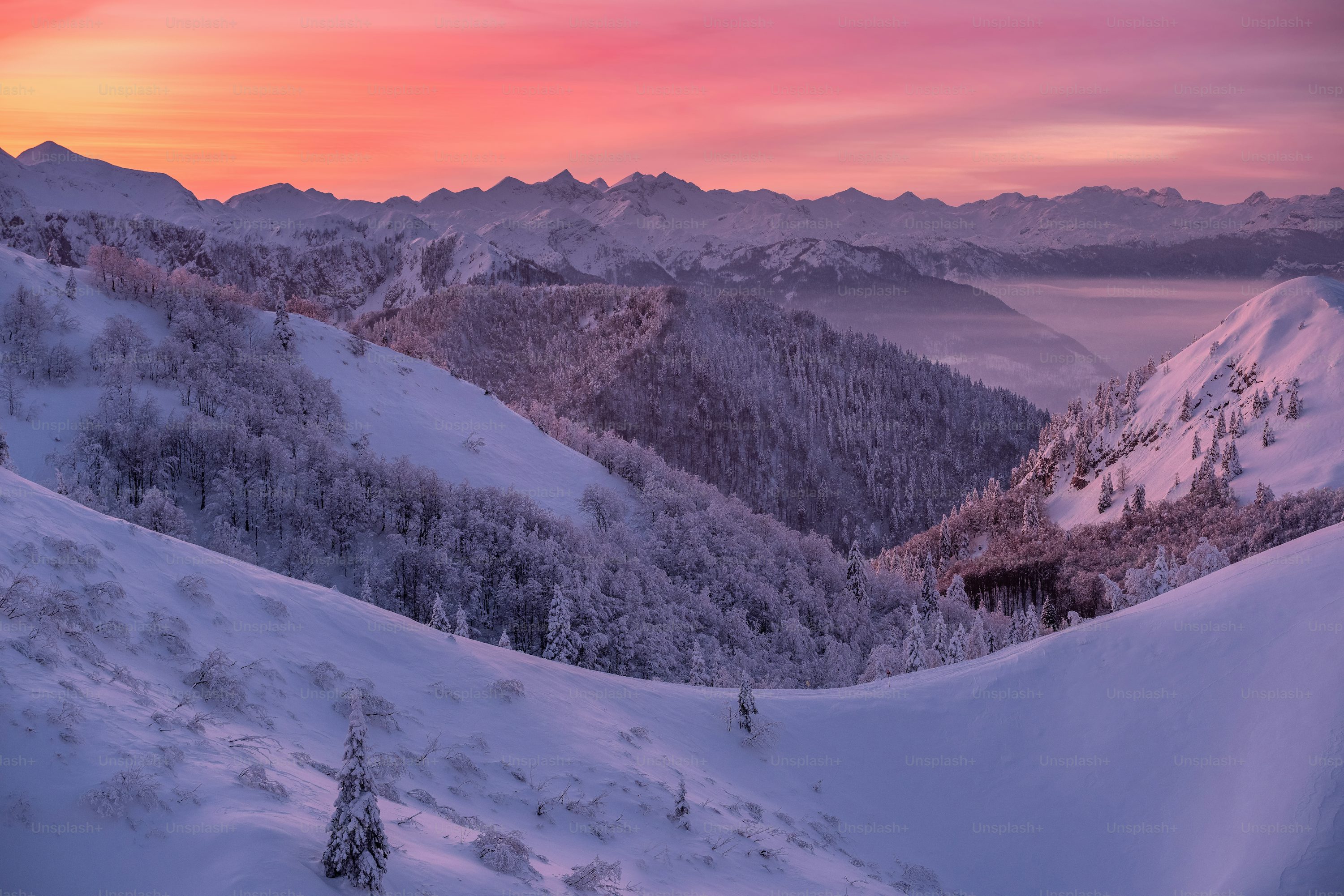 A sunset view of a snowy mountain range photo
