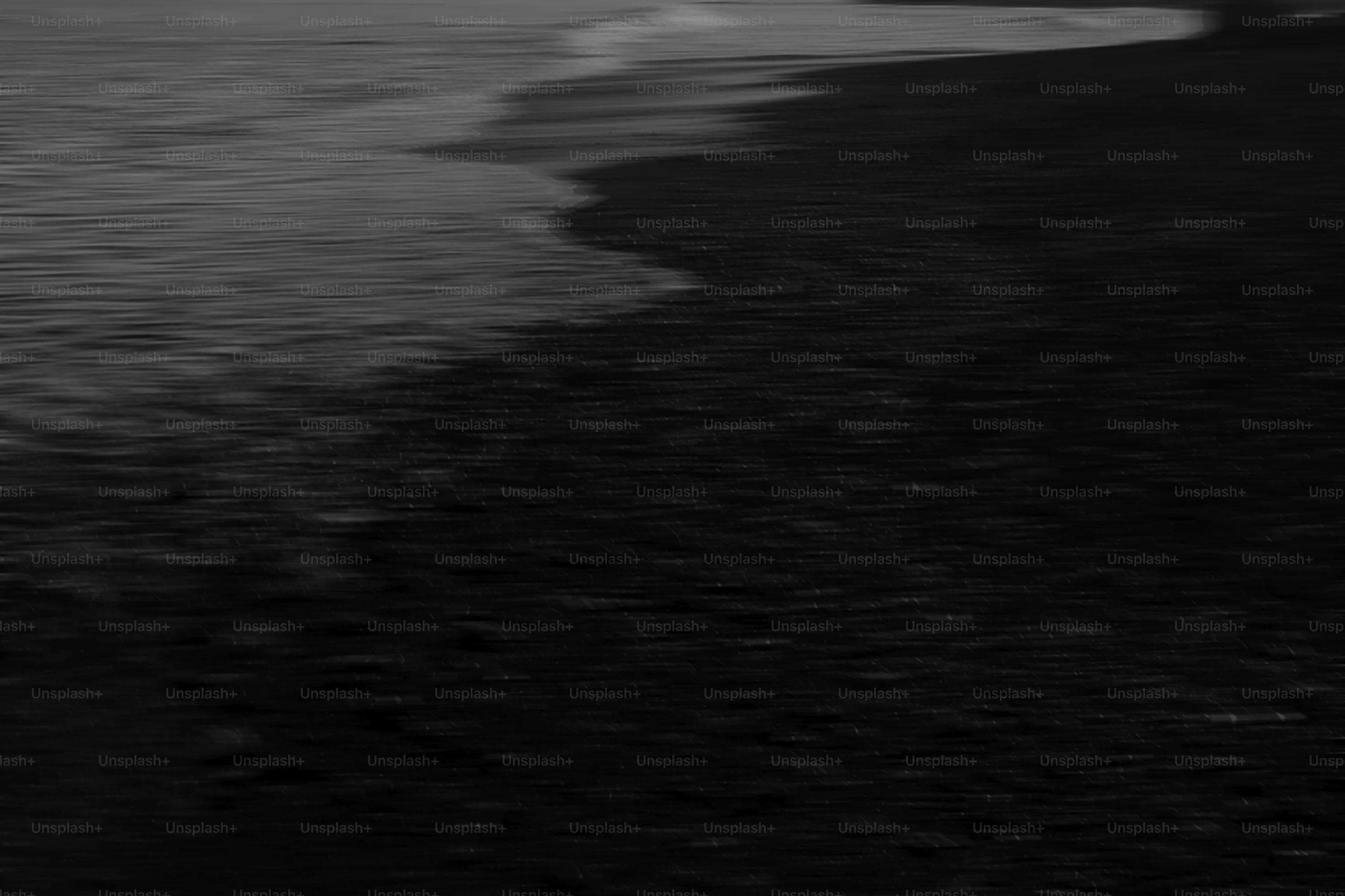 Dark beach with gentle waves lapping shore. photo