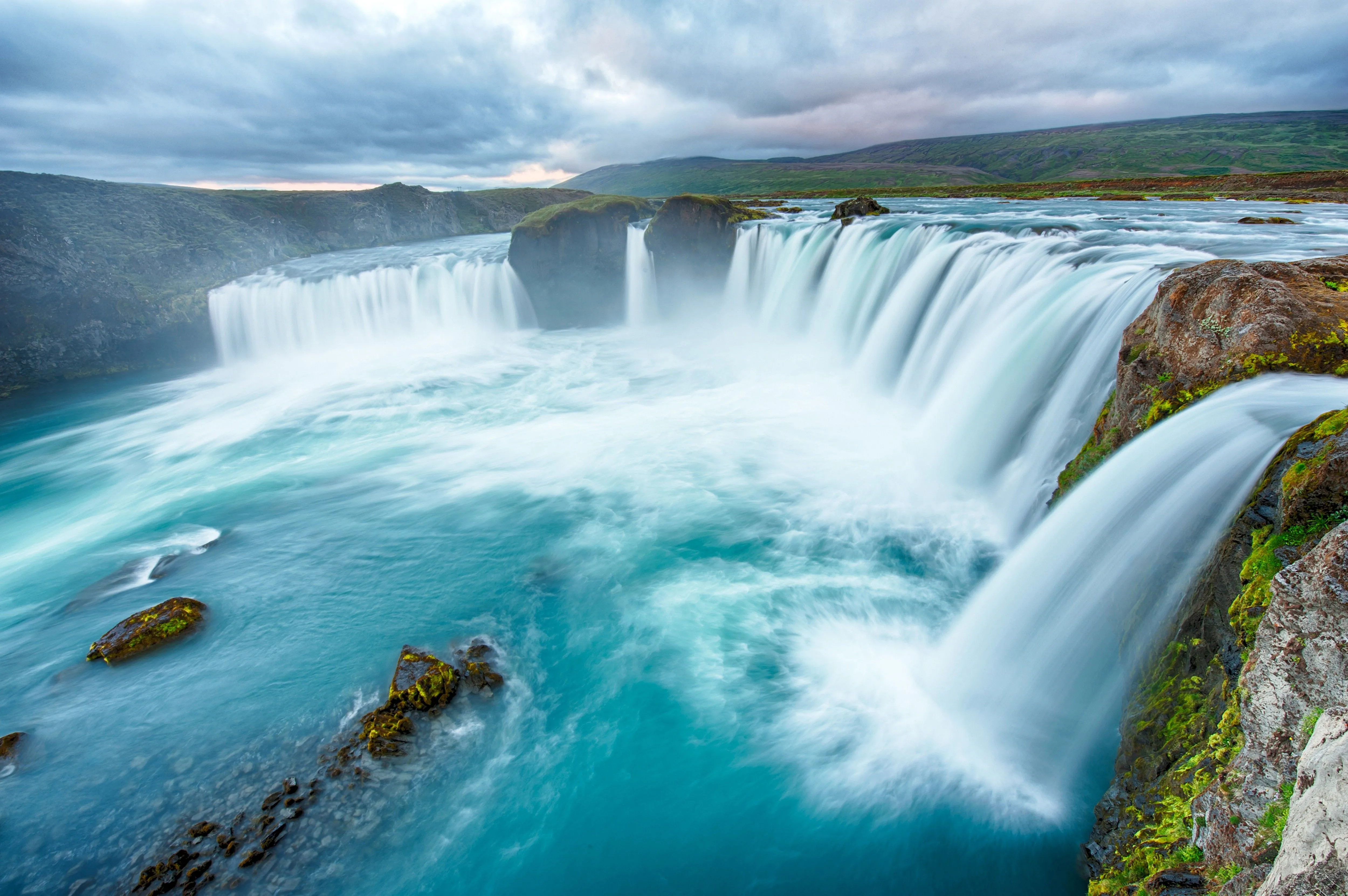 The rapid waterfall flows down from the cliff. Desktop wallpaper 600x382