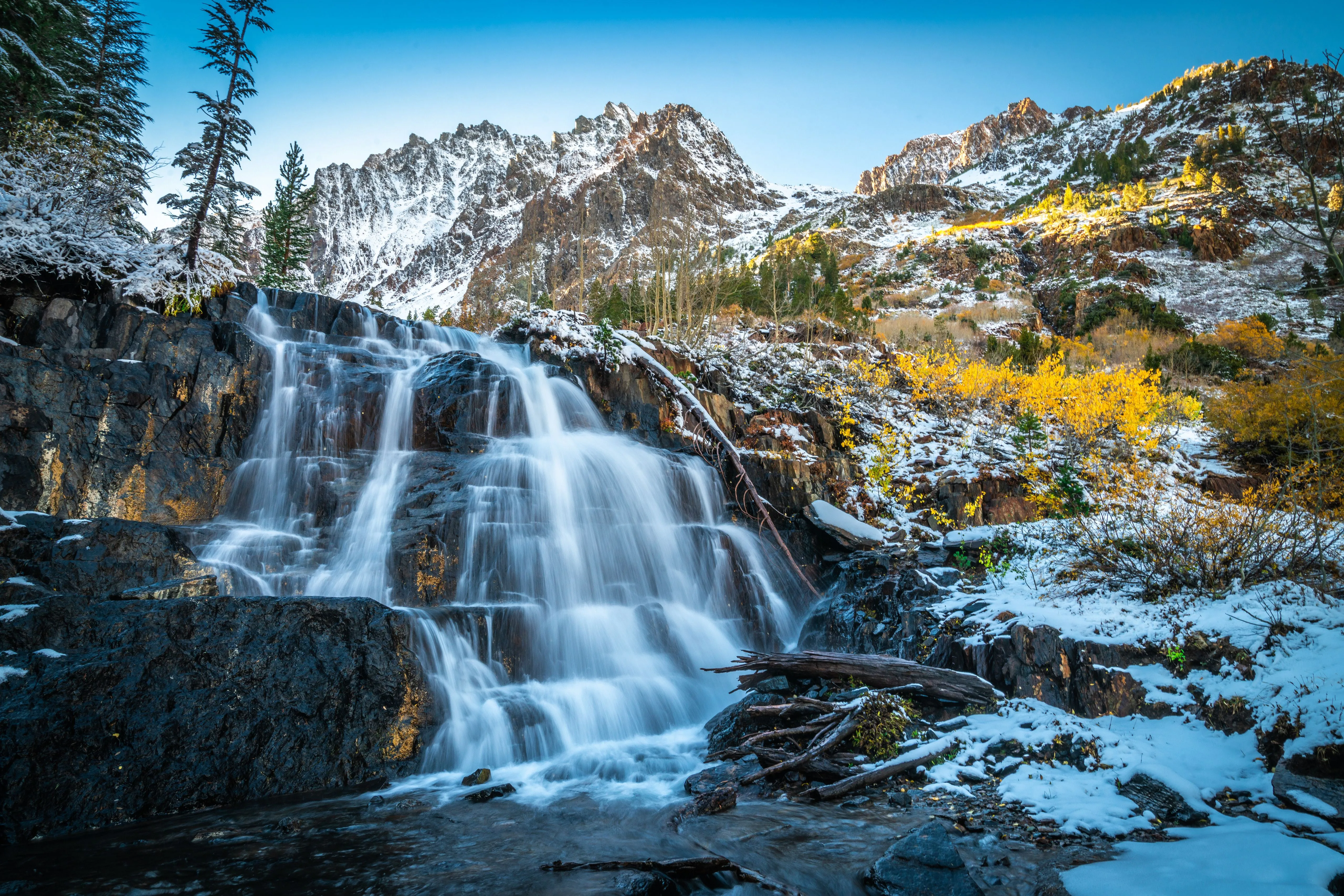 A Beautiful Waterfall Flows Down The Cold Stones Against The Backdrop Of Snow Capped Mountains Desktop Wallpaper 1280x1024